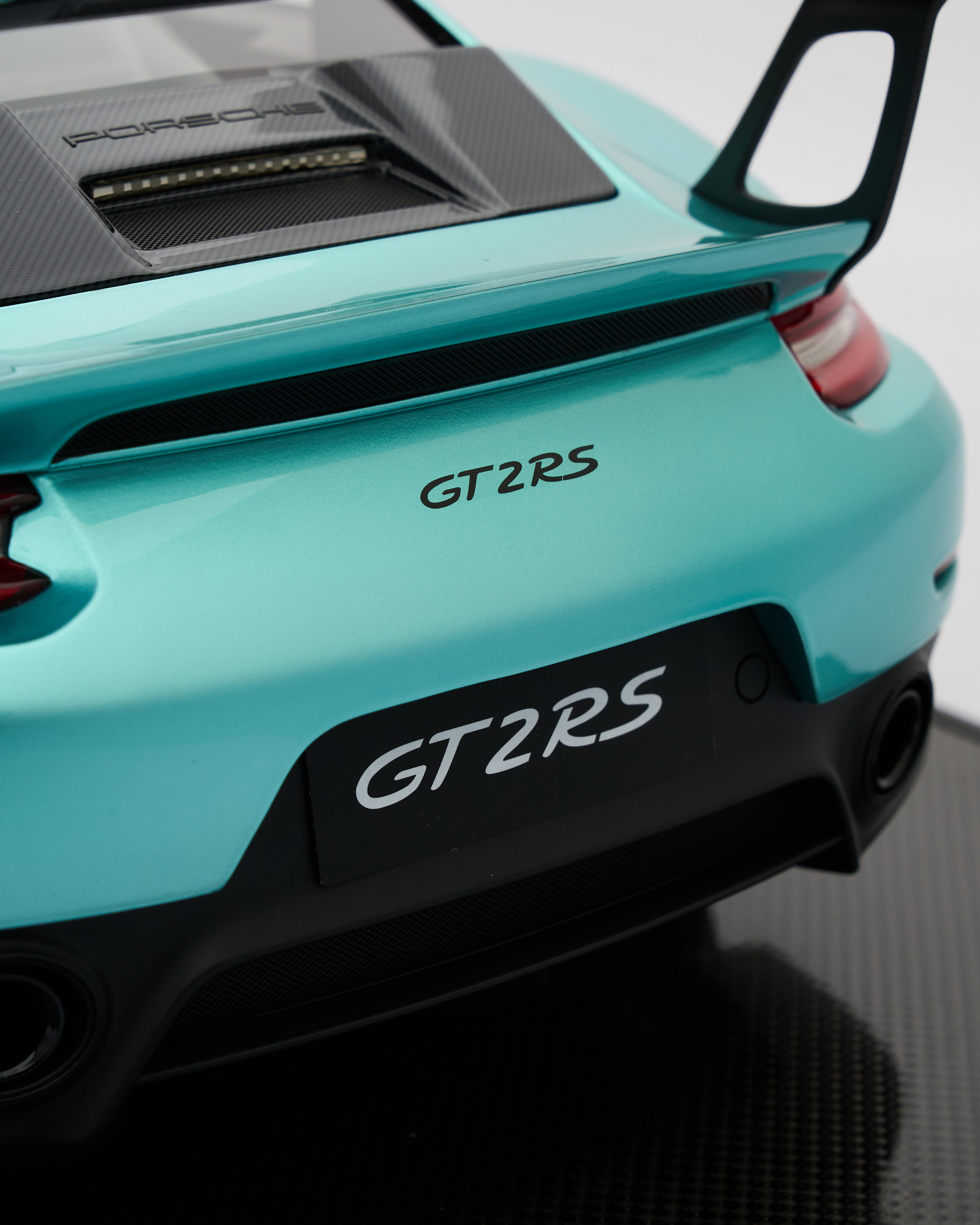 Close-up of a turquoise Porsche GT2 RS car rear with 'GT2 RS' branding.