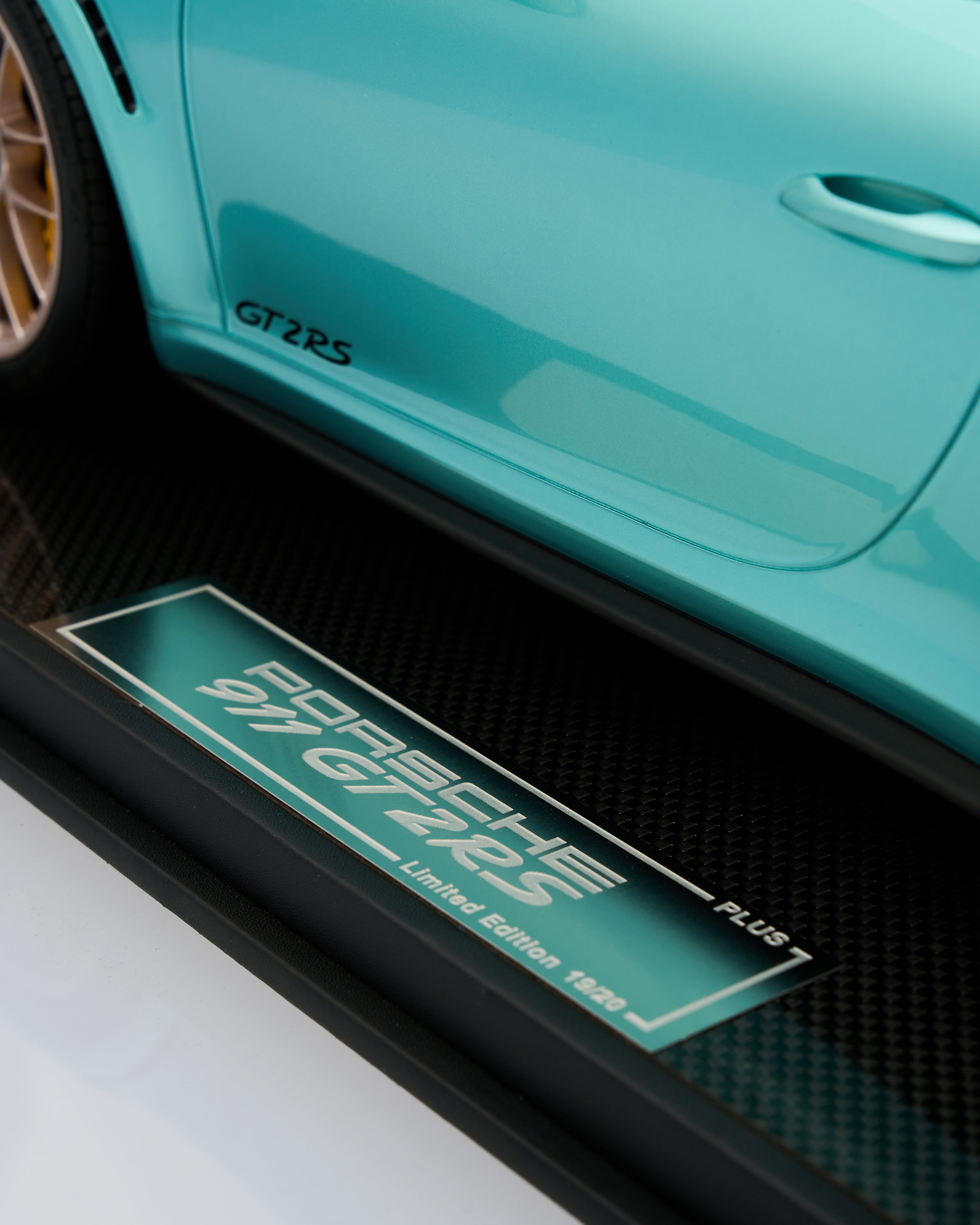 Close-up of a turquoise Porsche 911 GT2 RS car door with a logo and text.