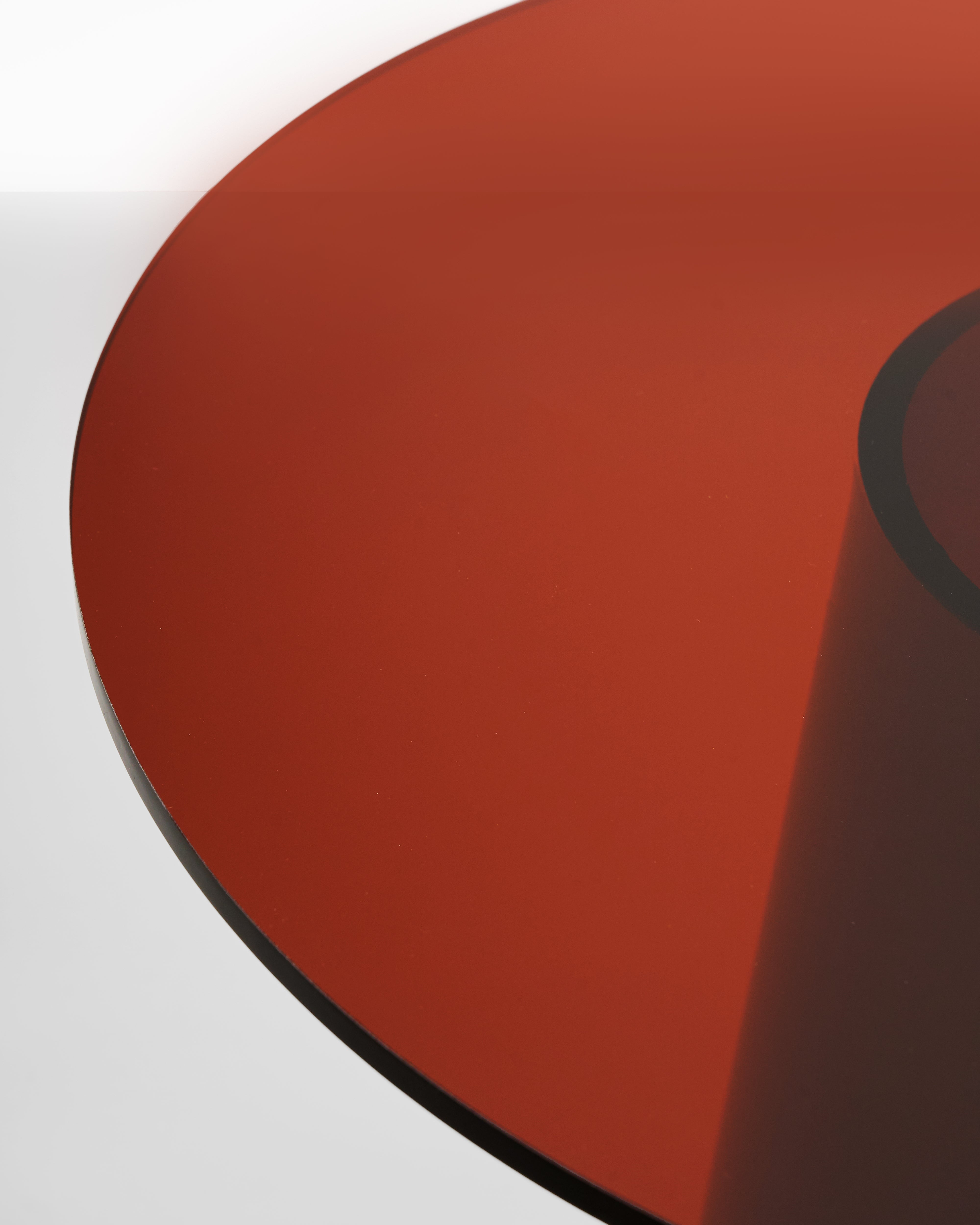 Close-up of a red circular acrylic side table material on a white background