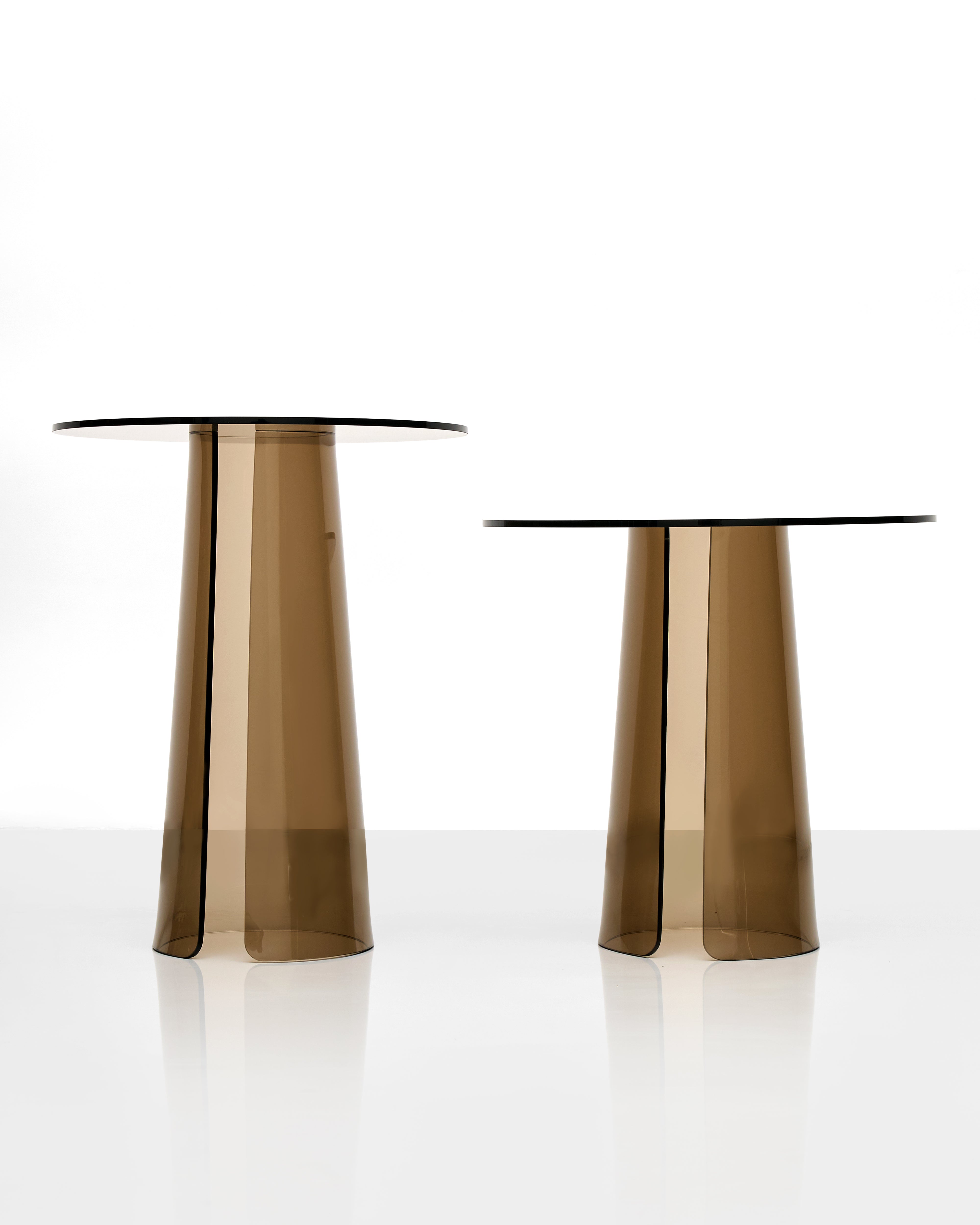Two transparent brown acrylic side tables on a white background