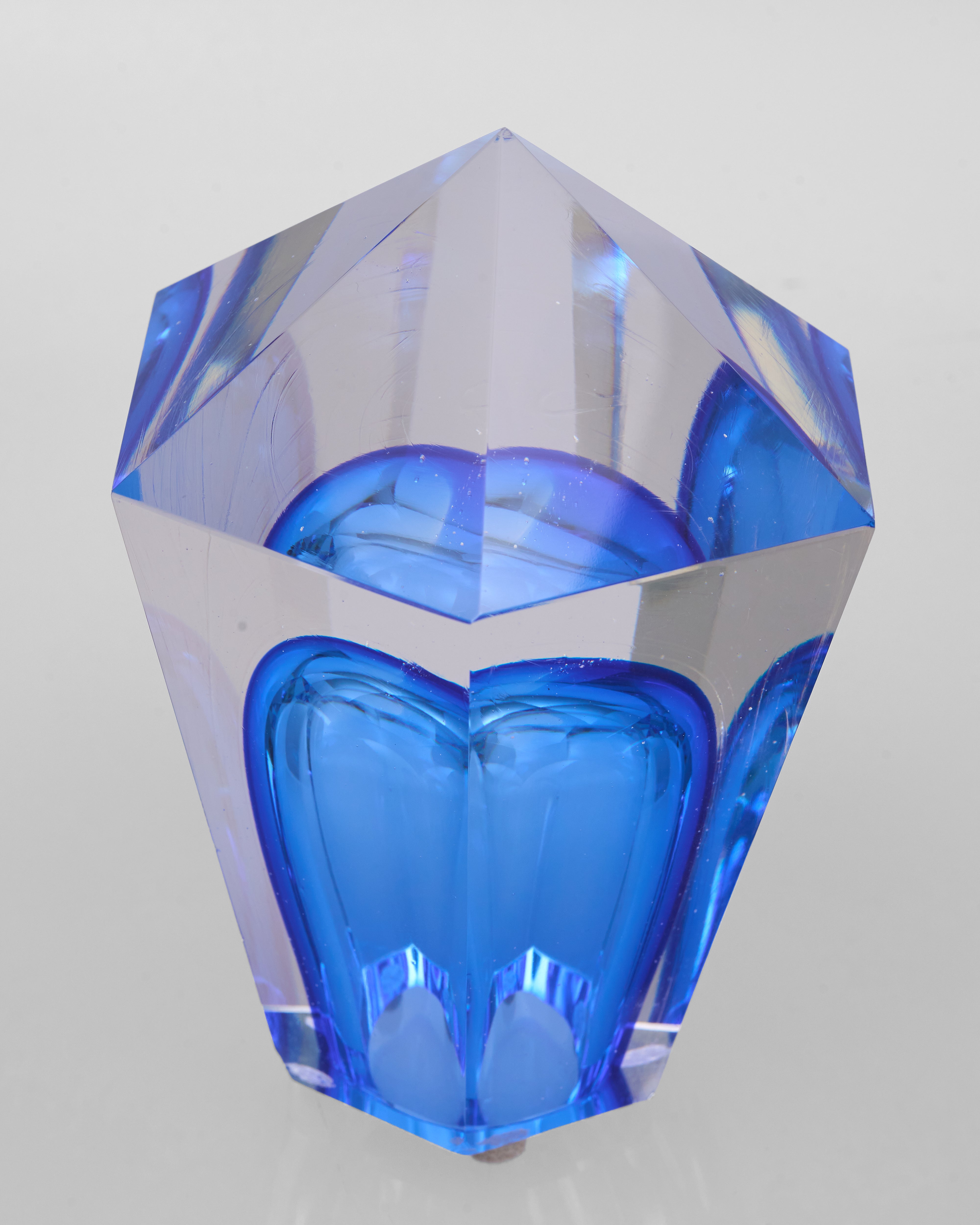 Blue geometric crystal object on a light gray background