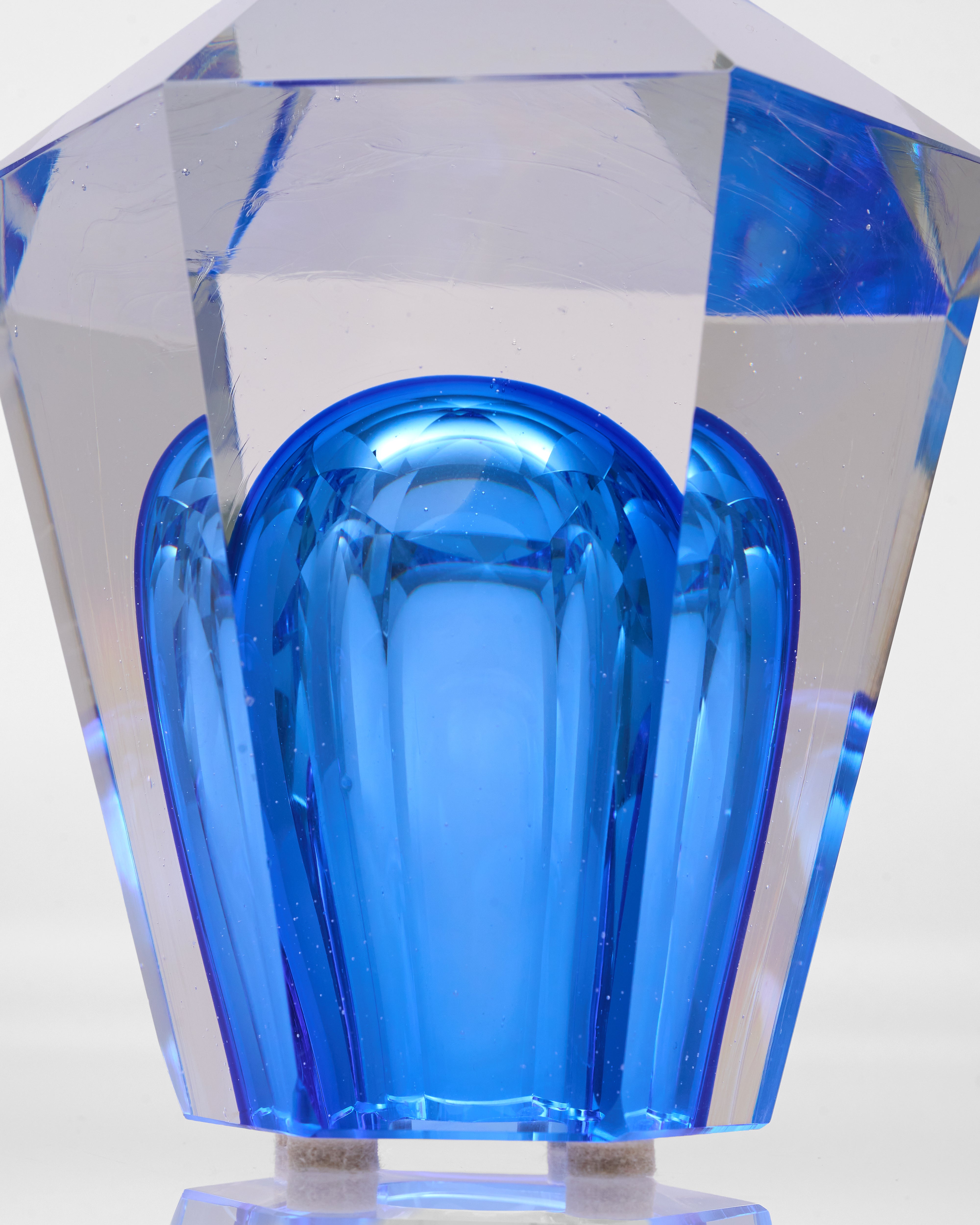 Blue glass vase with geometric design on a white background