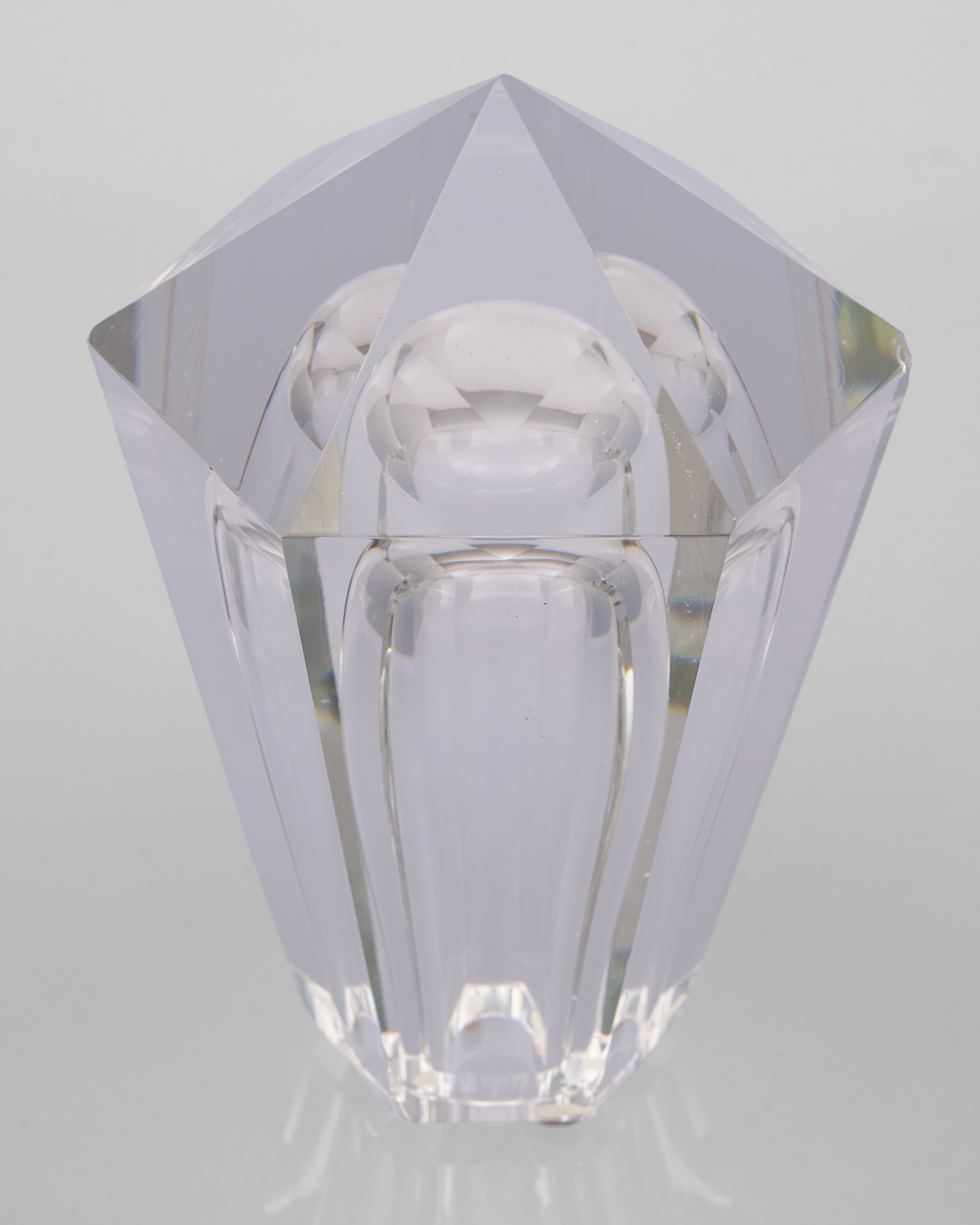 Clear crystal object with geometric design on a light gray background