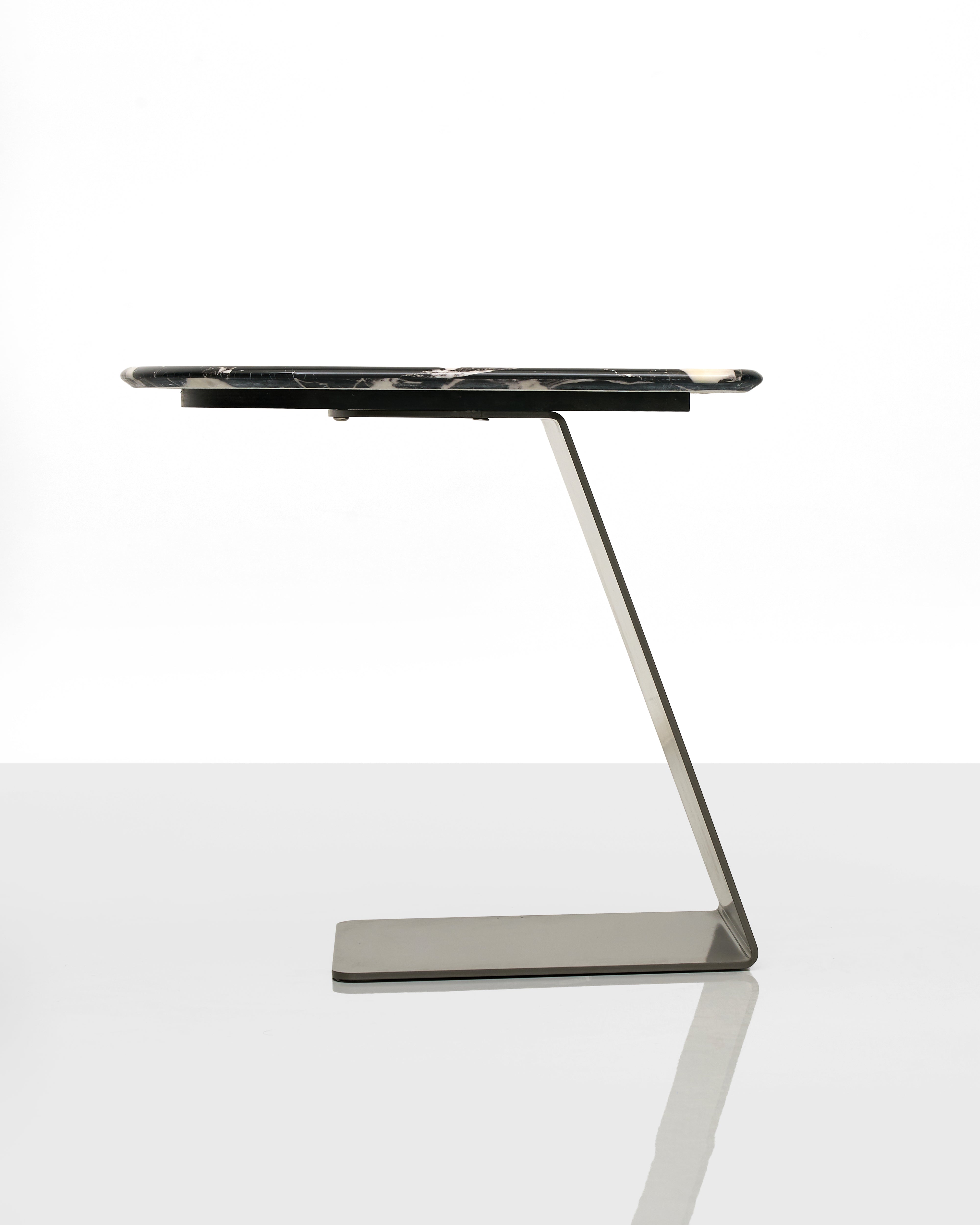 Modern marble side table with a black top on a white background