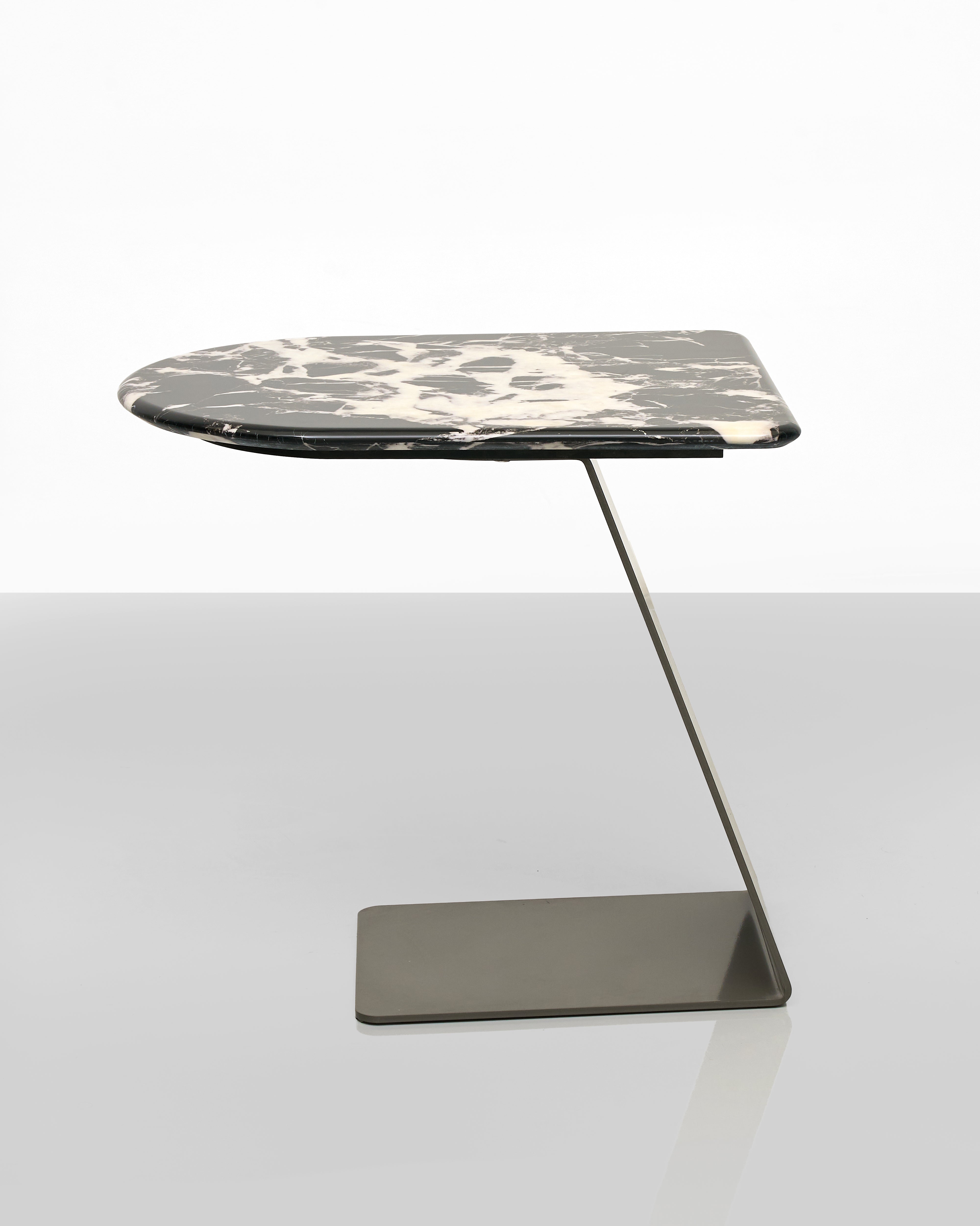 Modern side table with marble top and metal base on a white background