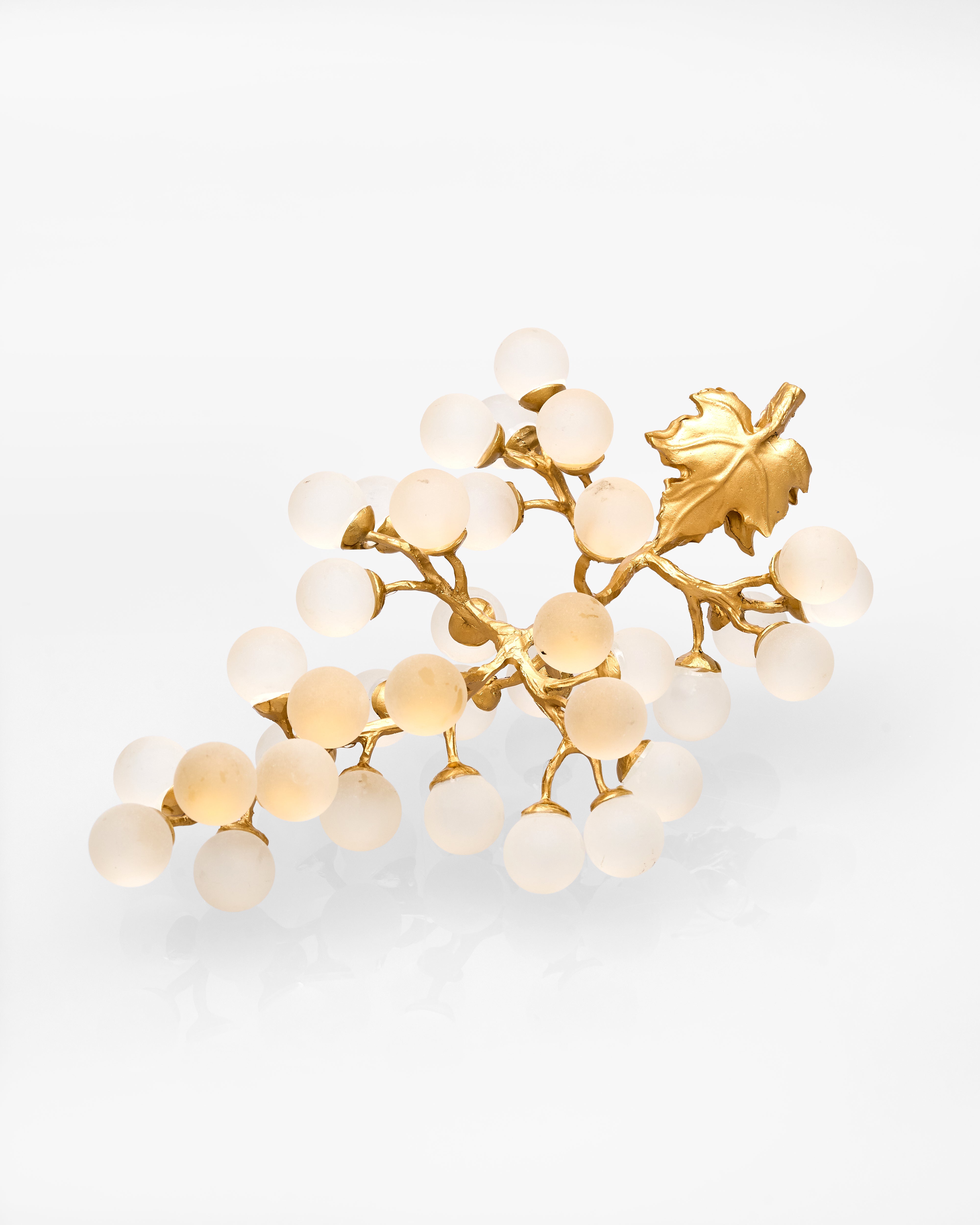 Gold and white decorative piece on a light gray background