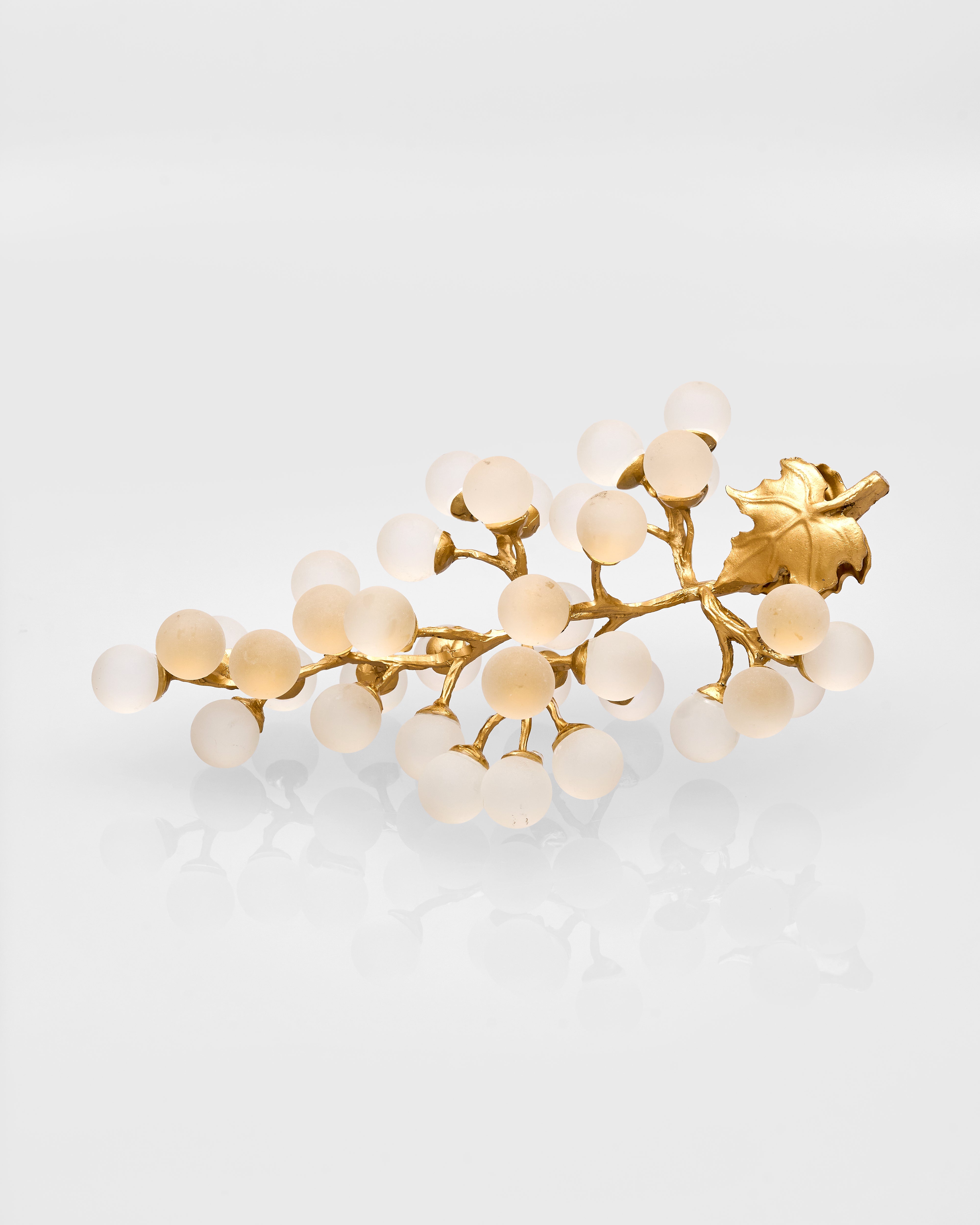 Gold hair vine with white grape decor metal on a light gray background