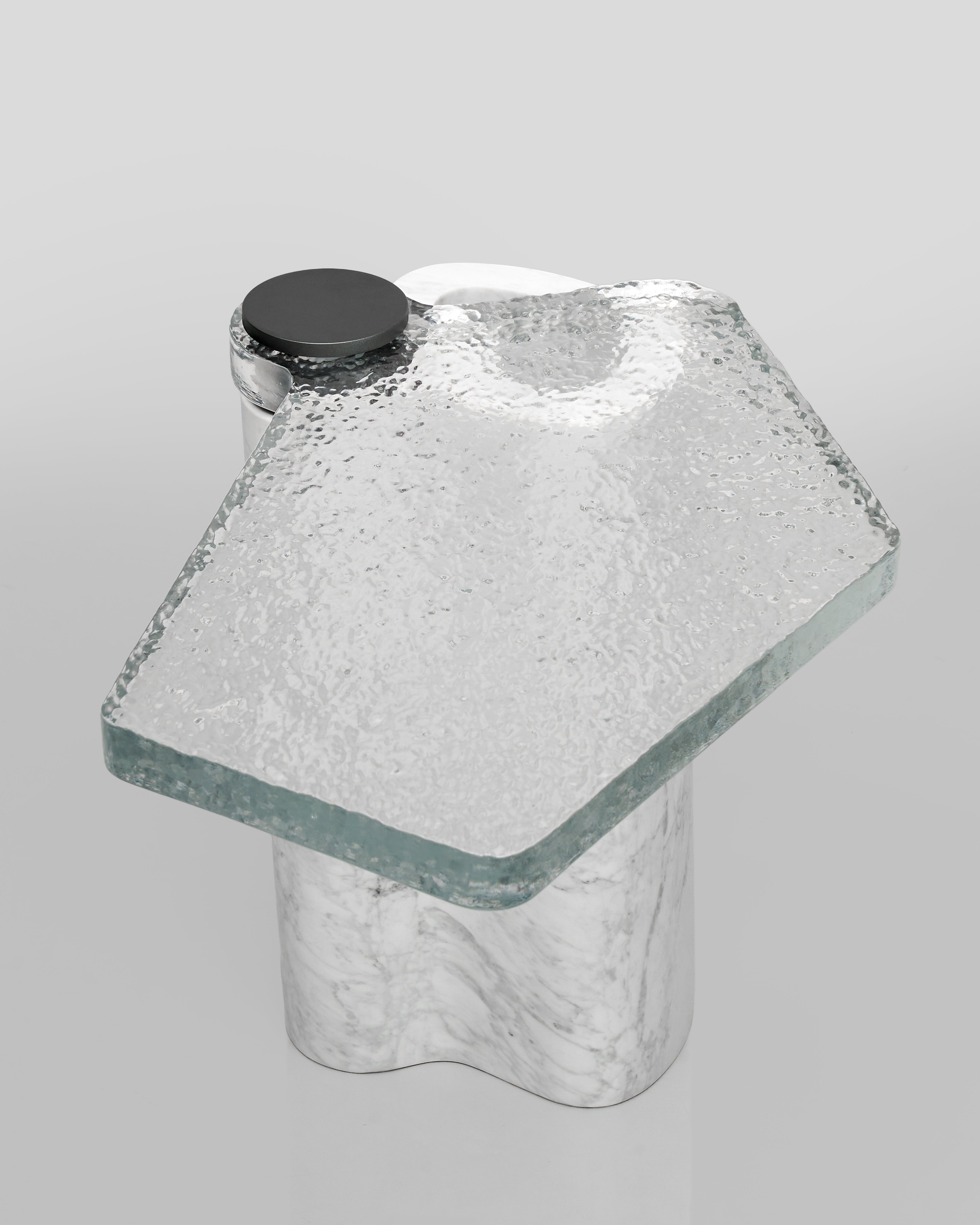 Clear glass side table with a black top on a gray background