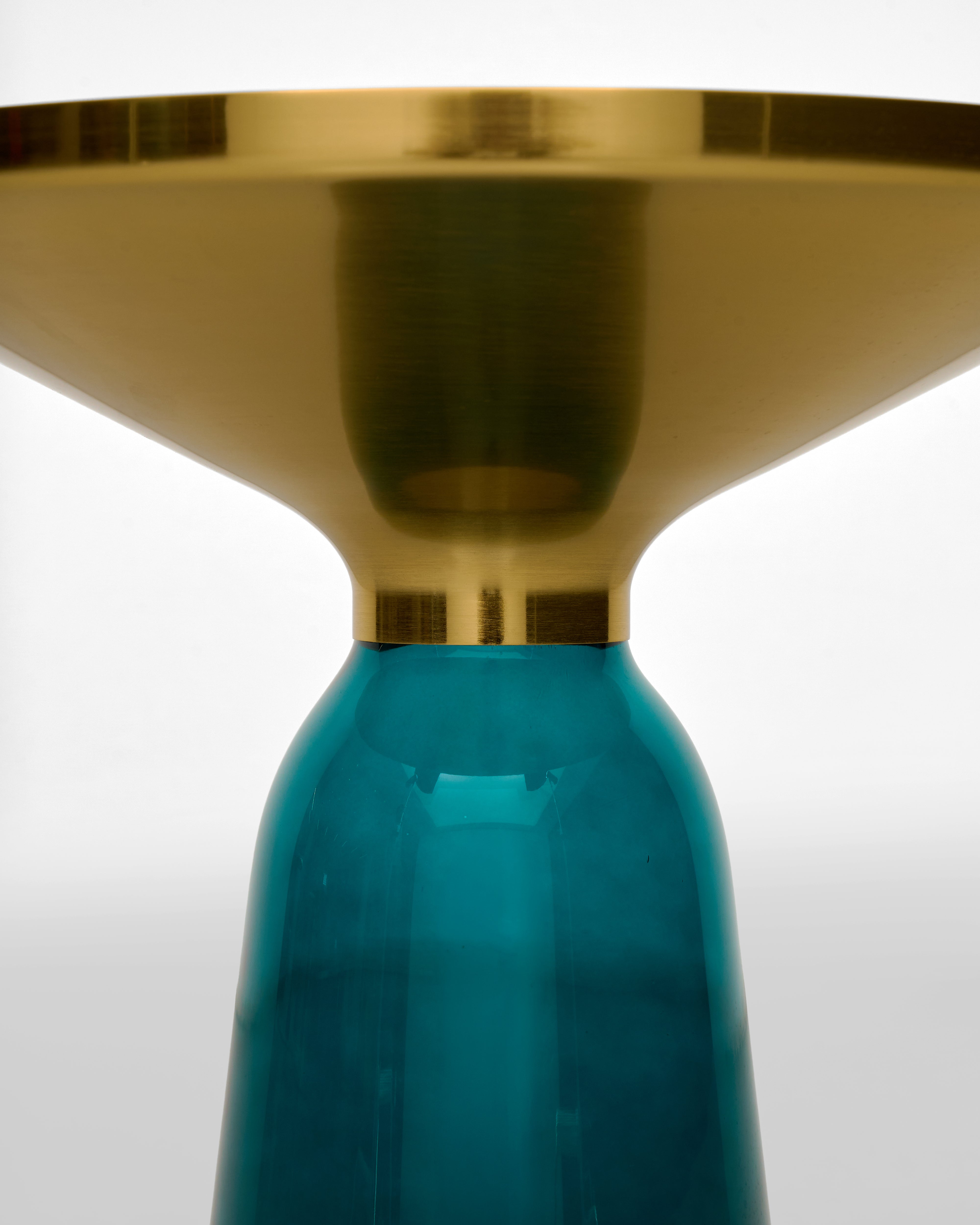 Teal glass object with gold metallic top on a white background