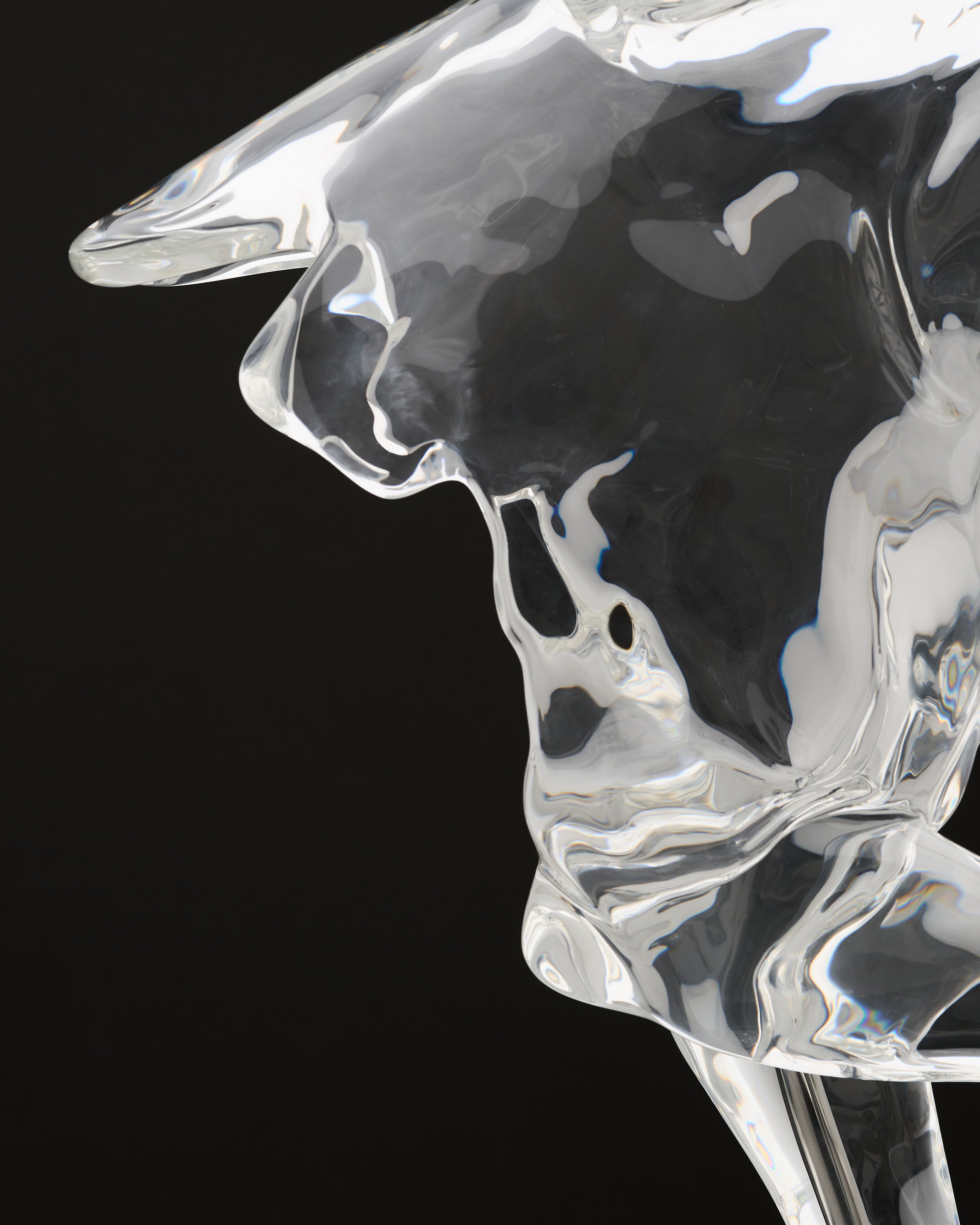 Clear glass sculpture of a horse head on a black background