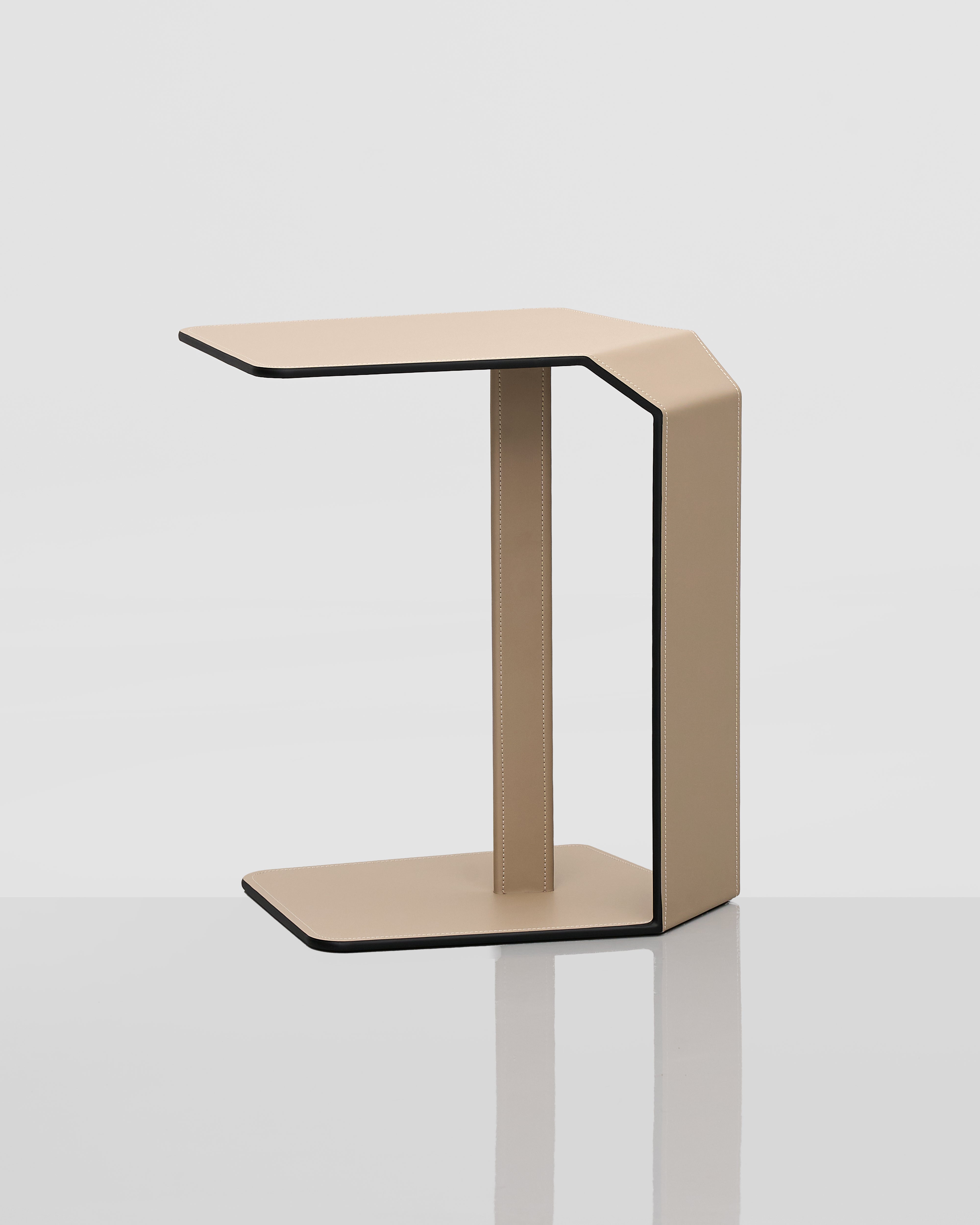 Modern side table with a geometric design and leather covering on a white background
