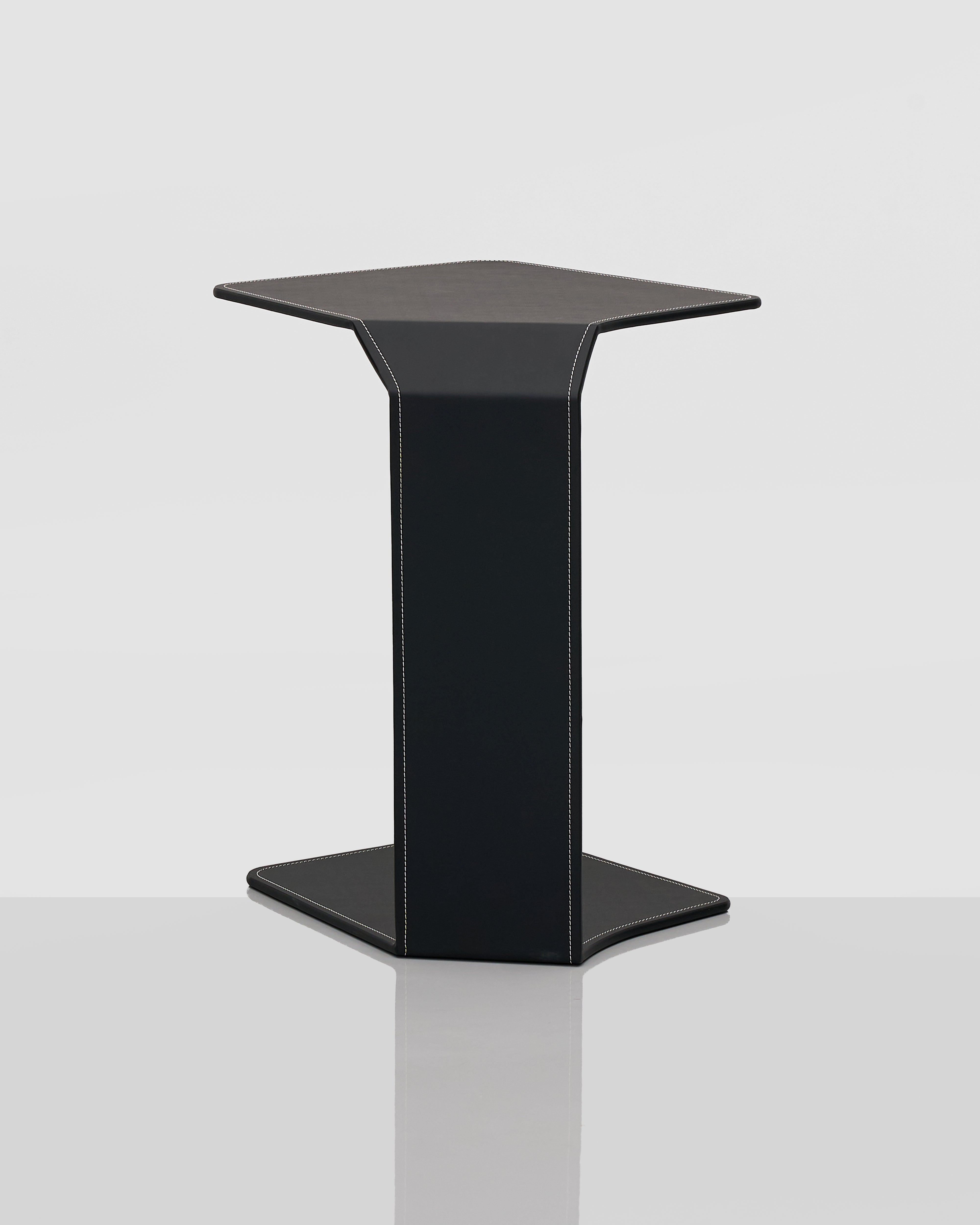 Black side table back side with black leather covering on a white background