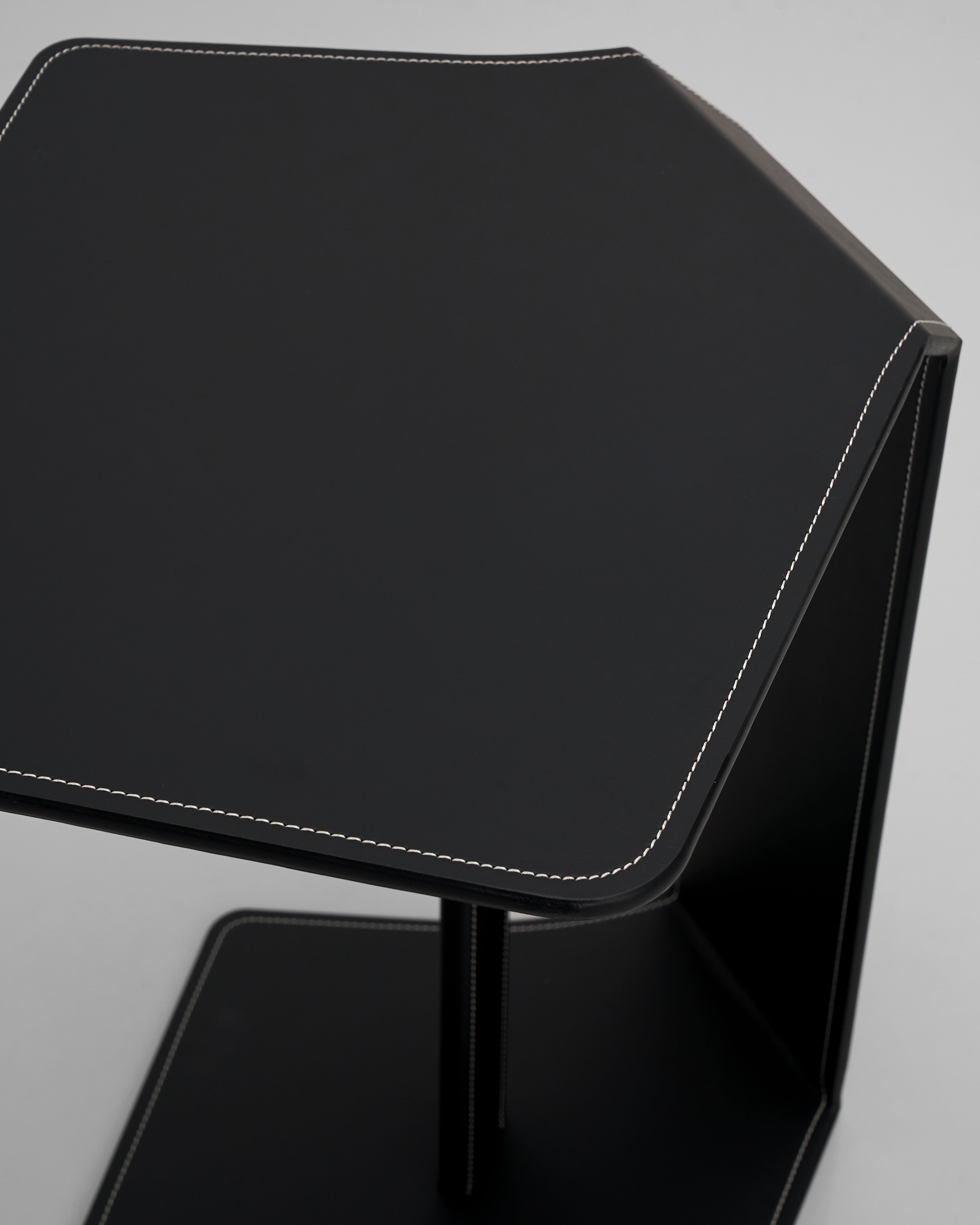 Black hexagonal side table on a gray background