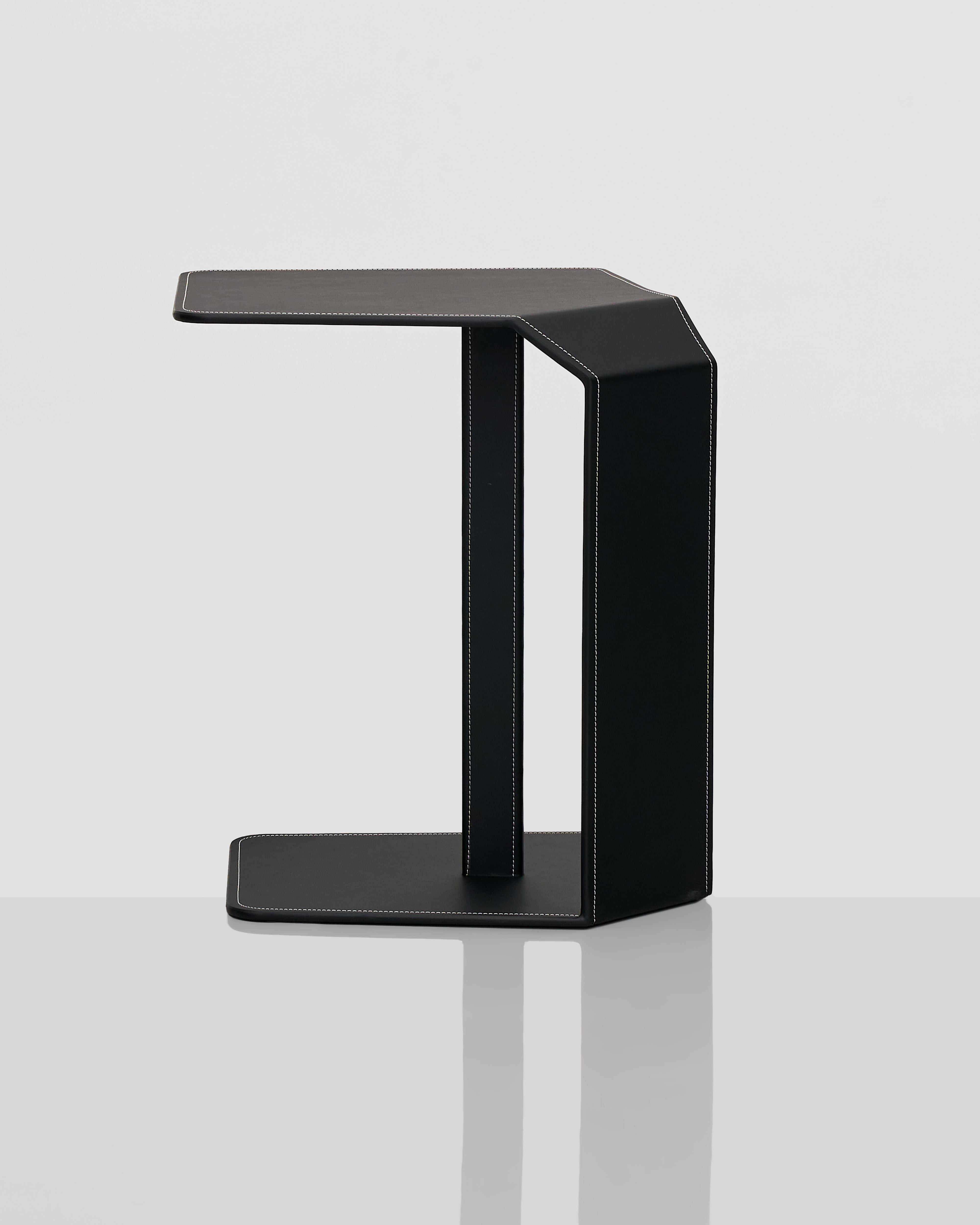 Black side table with black leather finish on a white background