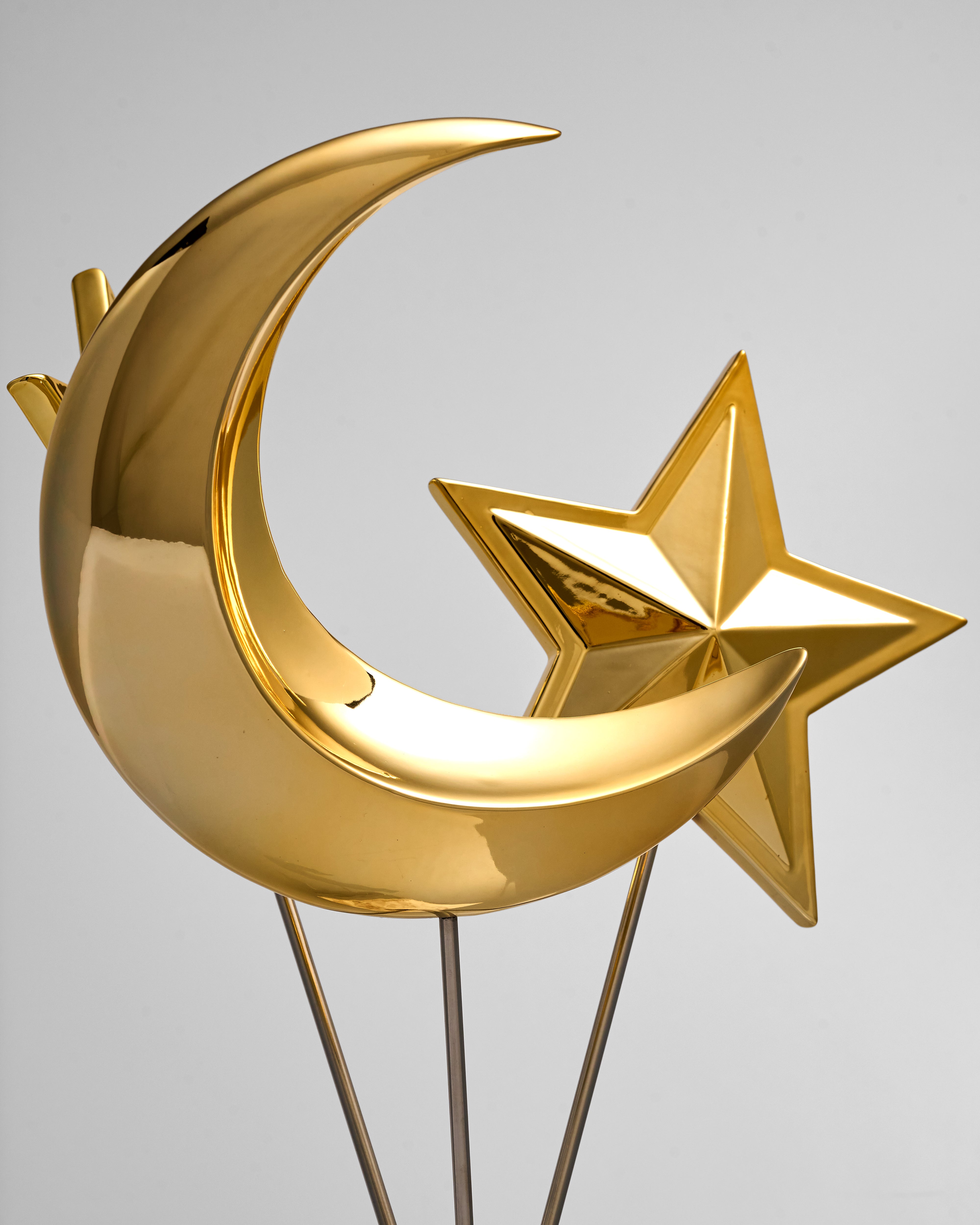 Gold metal moon and star decoration on a gray background