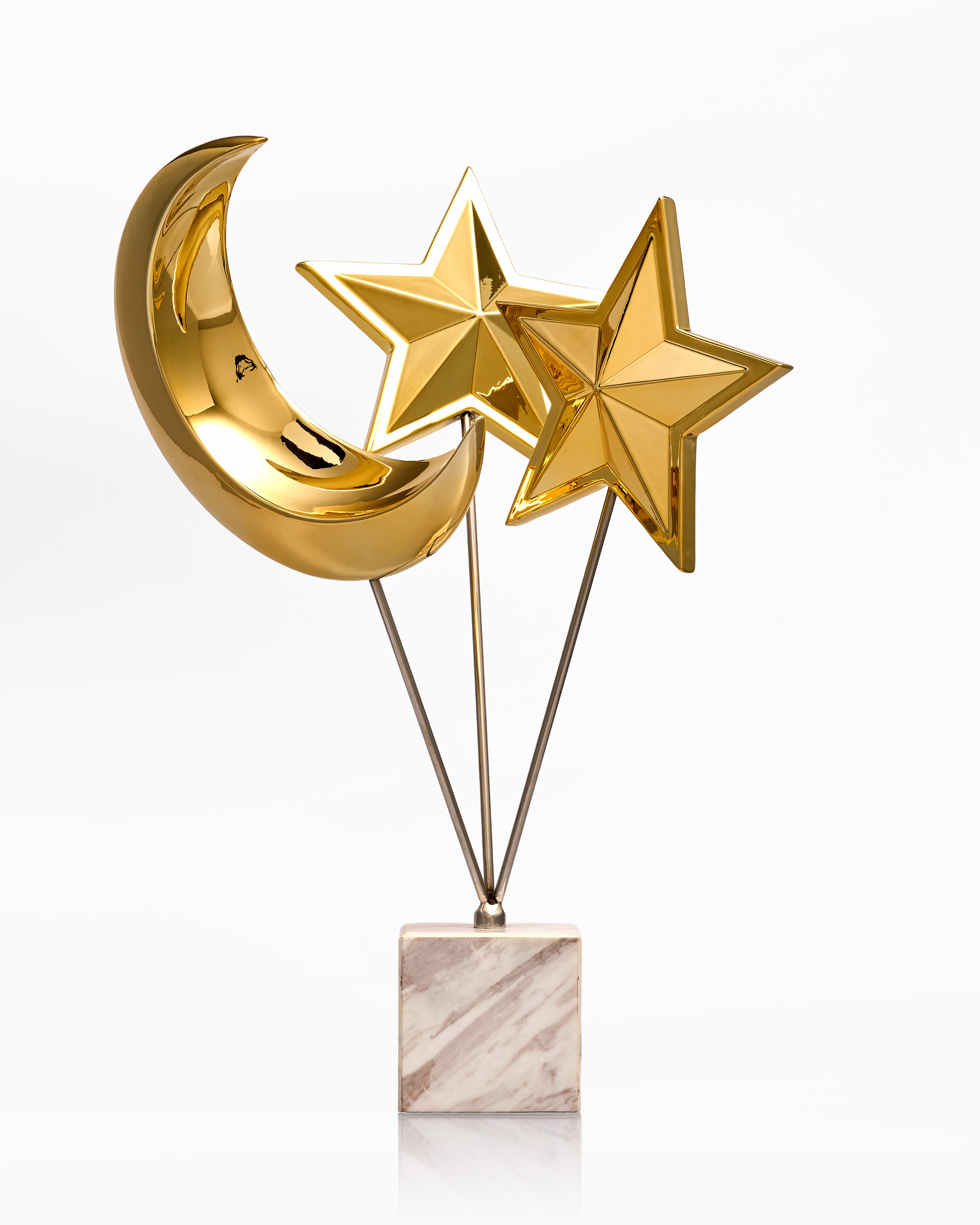 Decorative item with gold moon and stars on a marble base against a white background