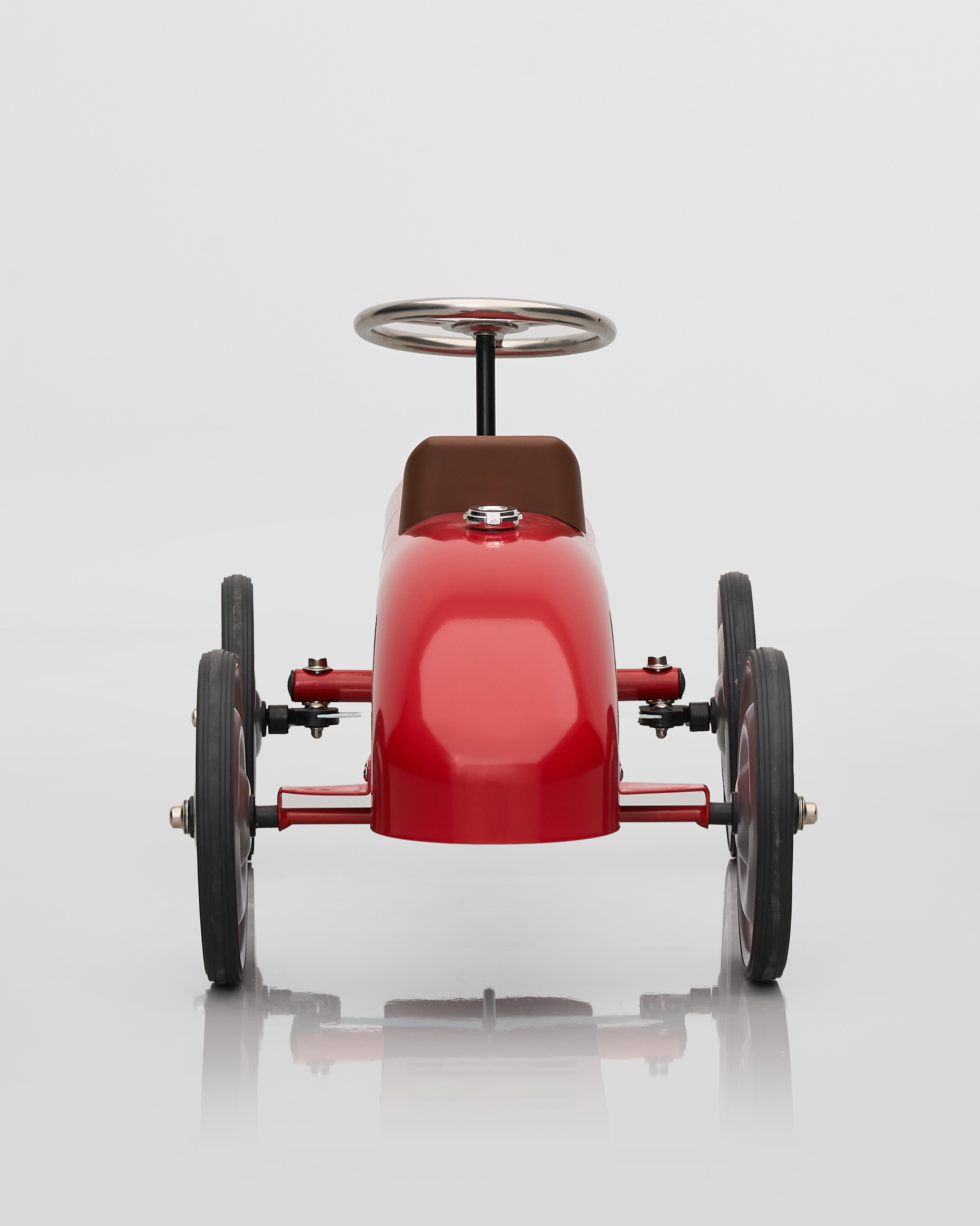 Red toy car decor with black wheels on a white background