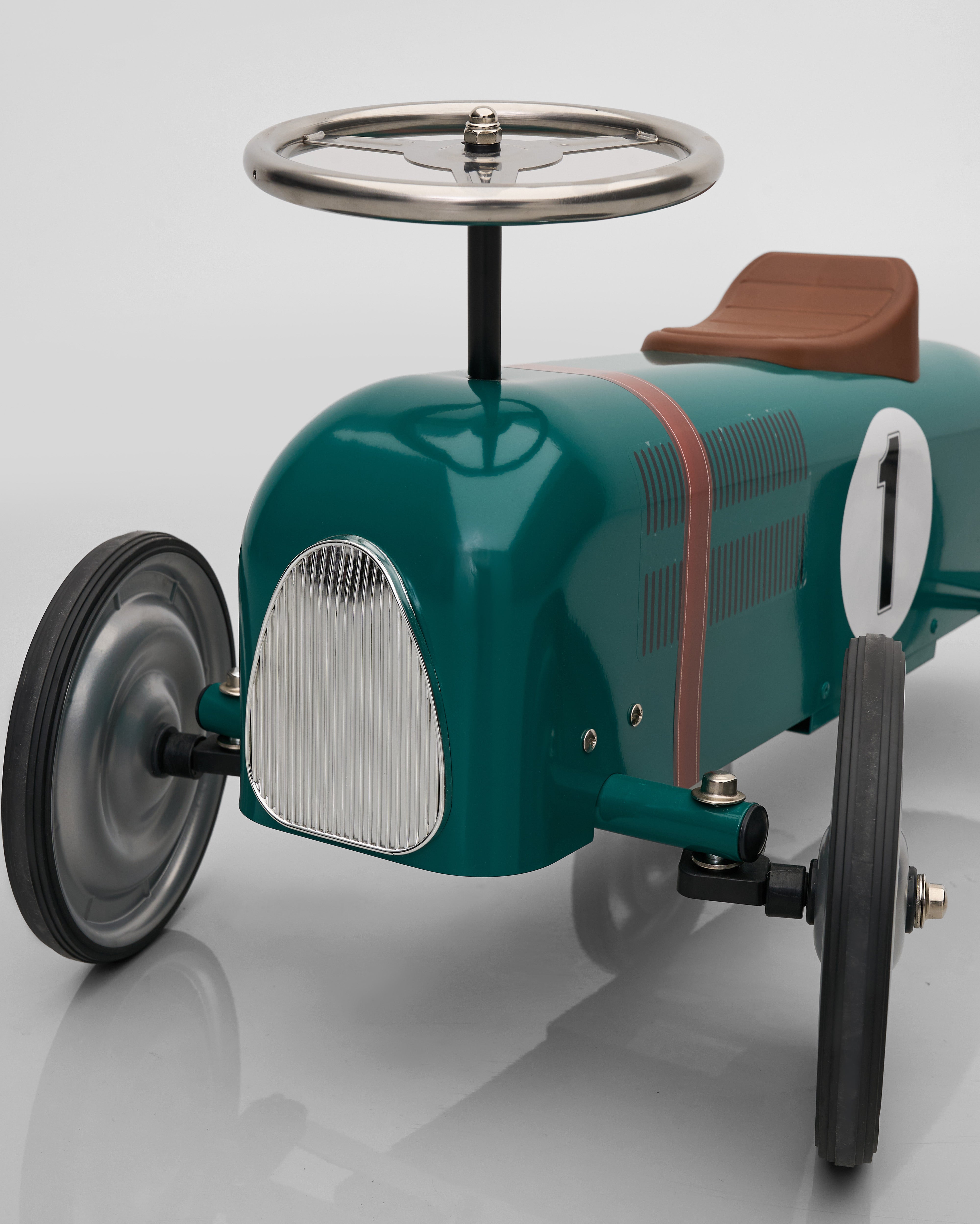 Vintage-style toy car with a steering wheel on a white background