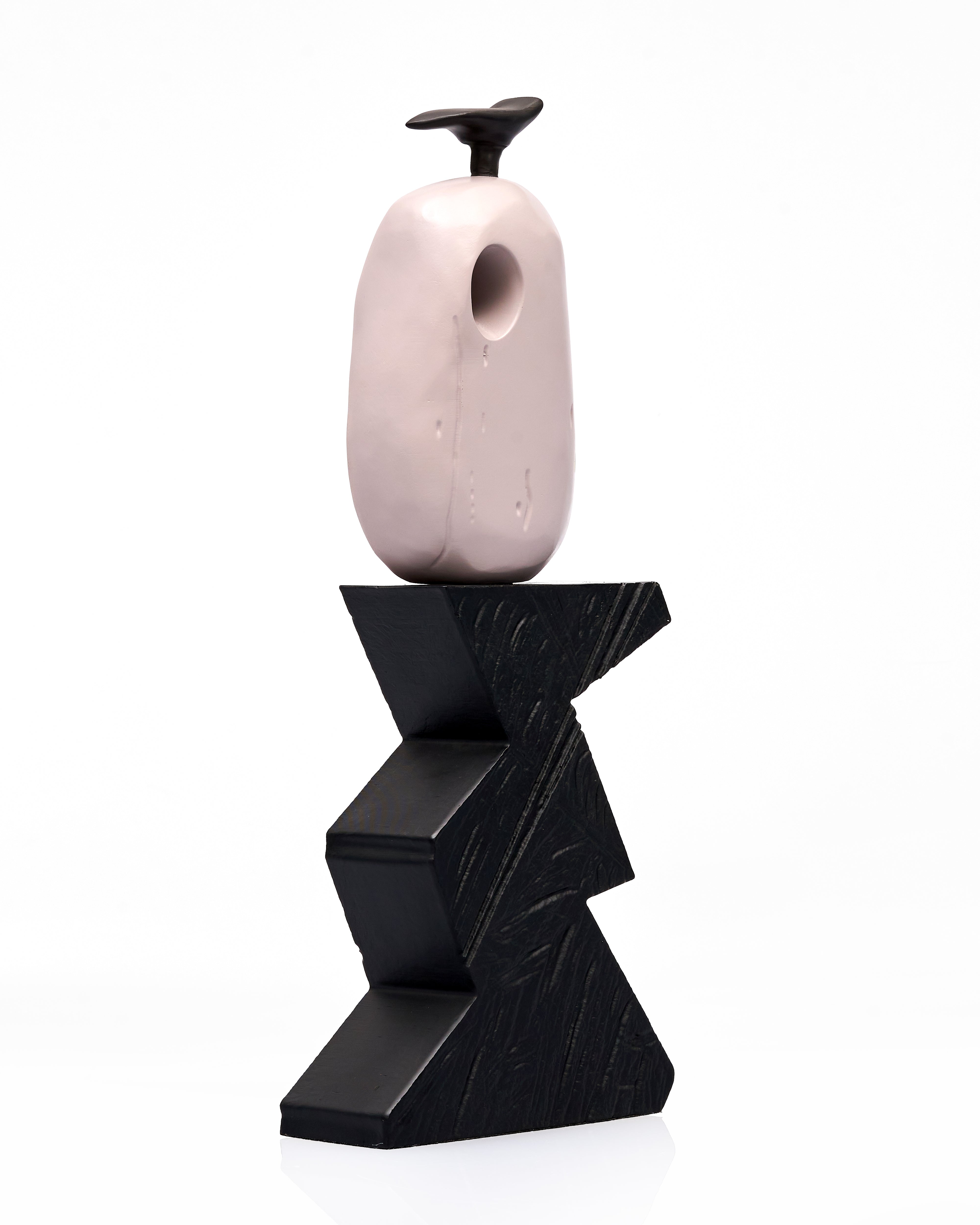 Pink wooden vase on a black zigzag base against a white background
