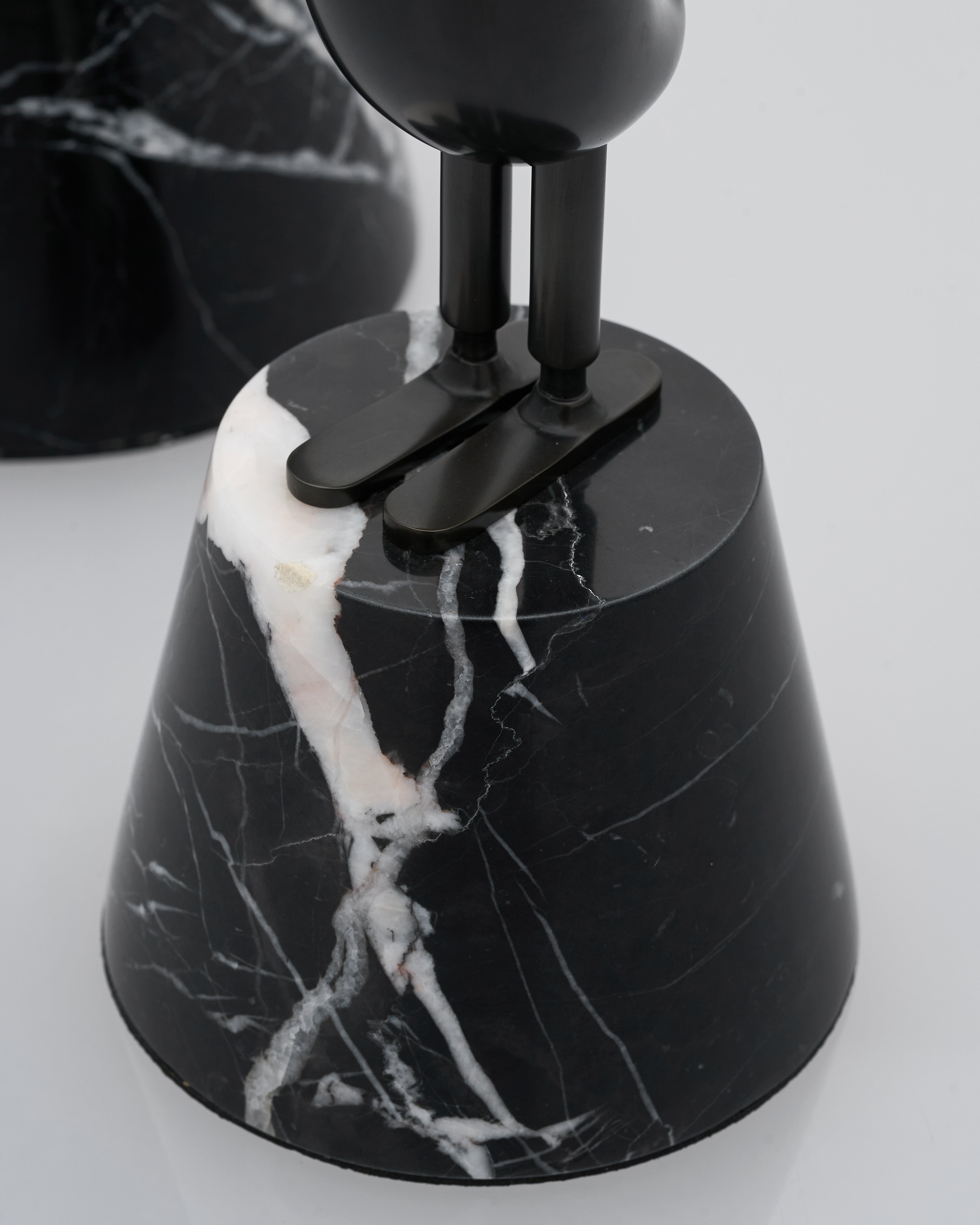 Black marble-patterned figurine closeup inside on a light gray background
