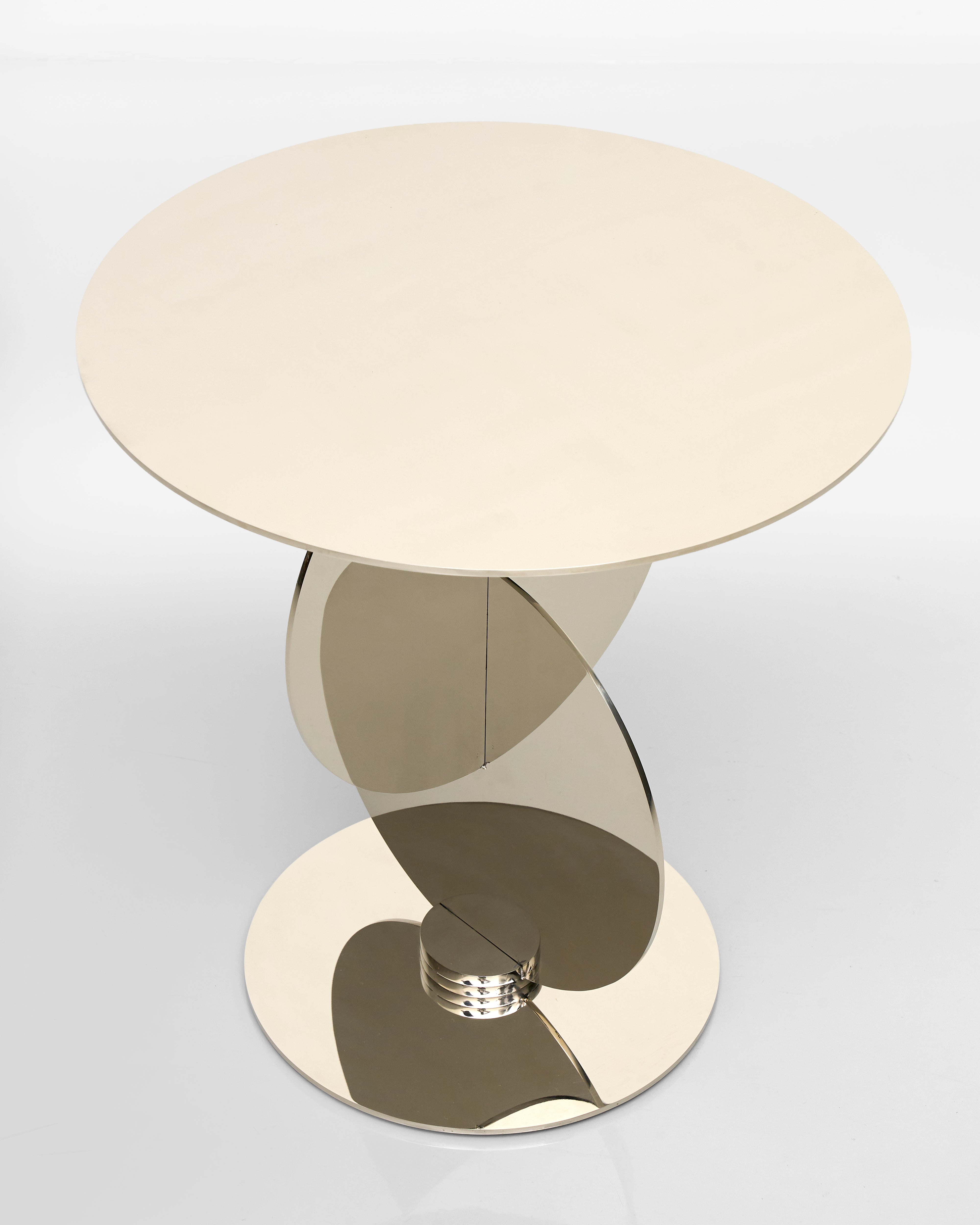Round side table with a beige top and gold base on a white background