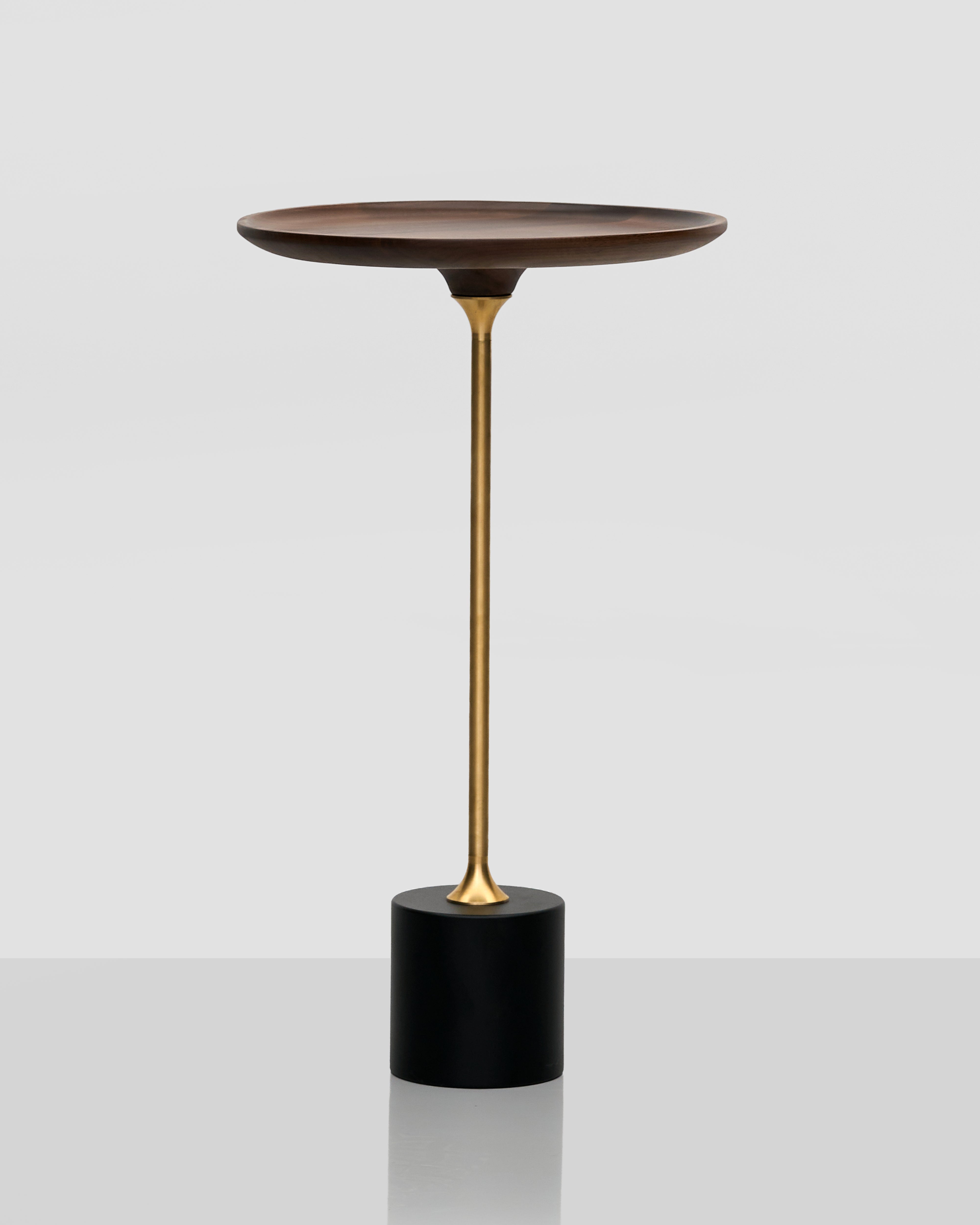 Modern side table with a bronze base and wooden top on a white background