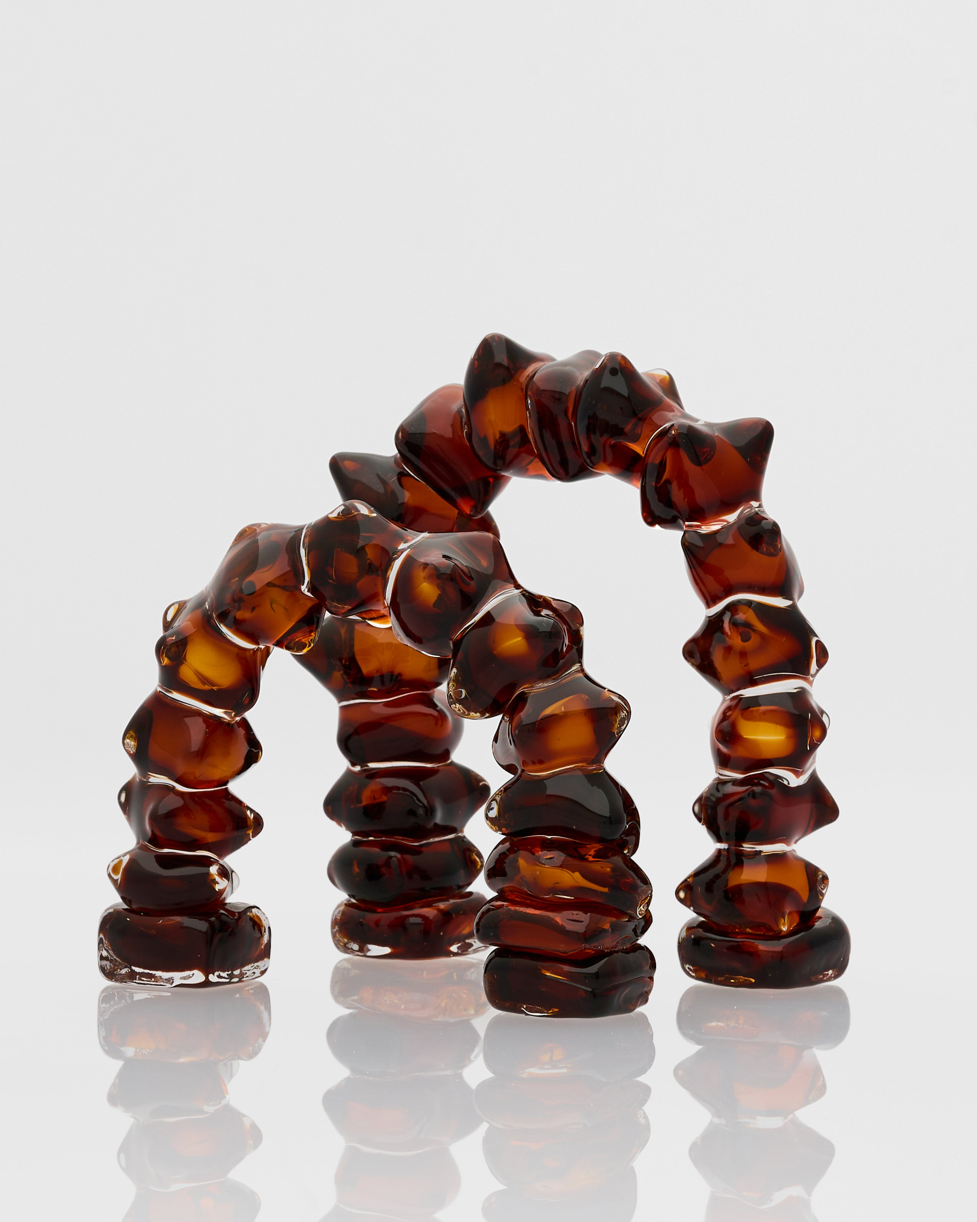 Brown textured ring on a reflective surface with a light gray background