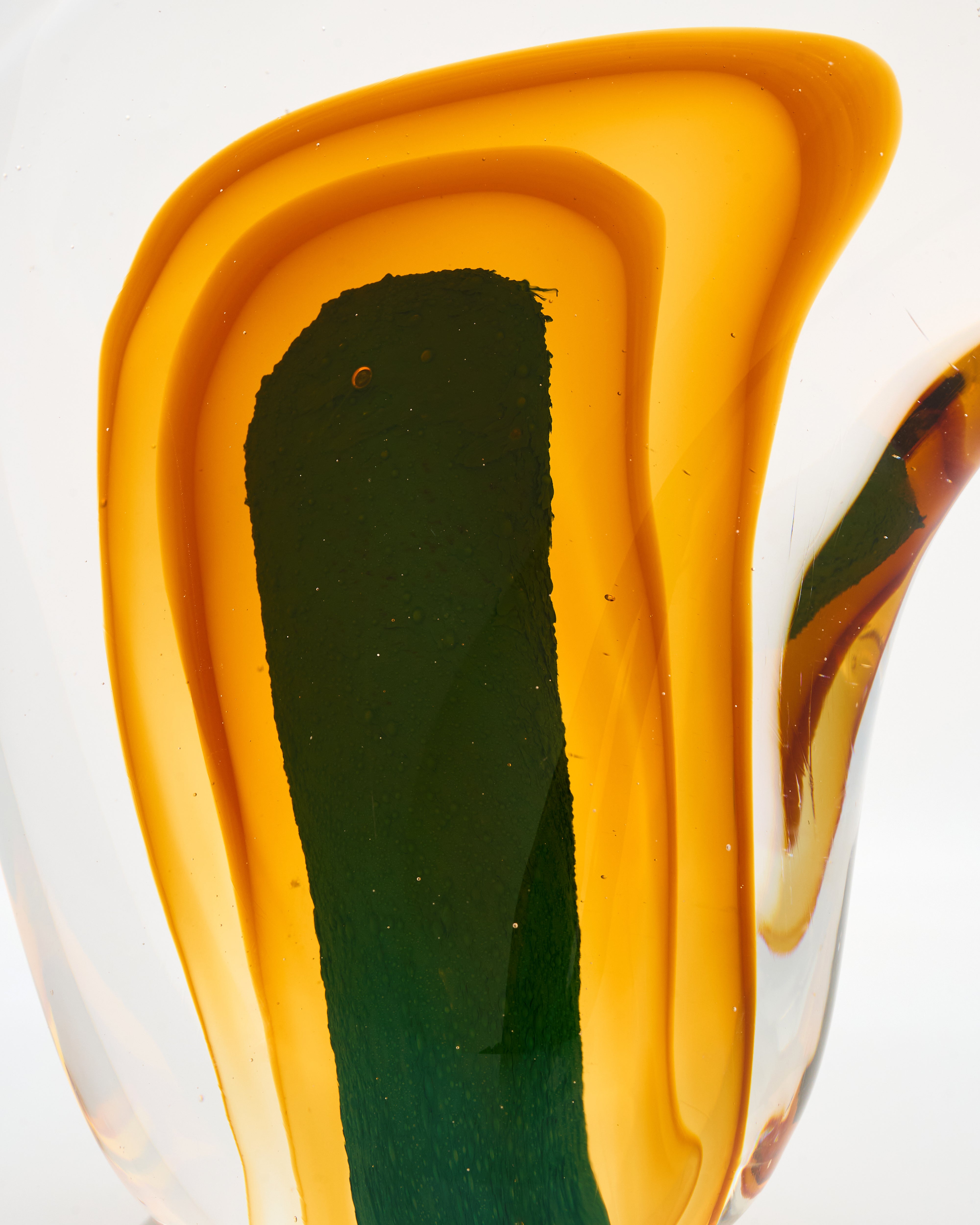 Close-up of a glass vase with wavy design and multicolored layers on a white background