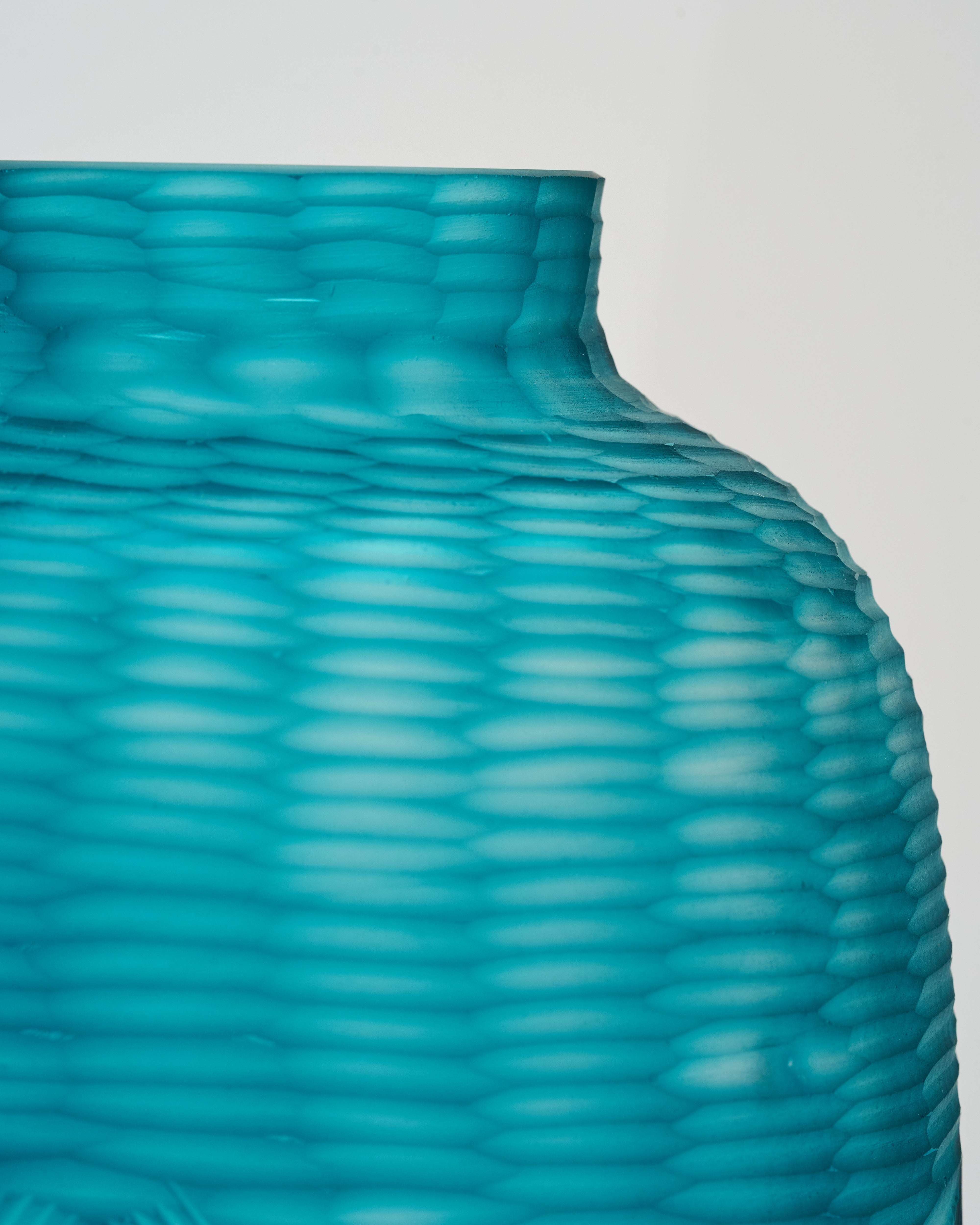 Teal textured vase on a light gray background