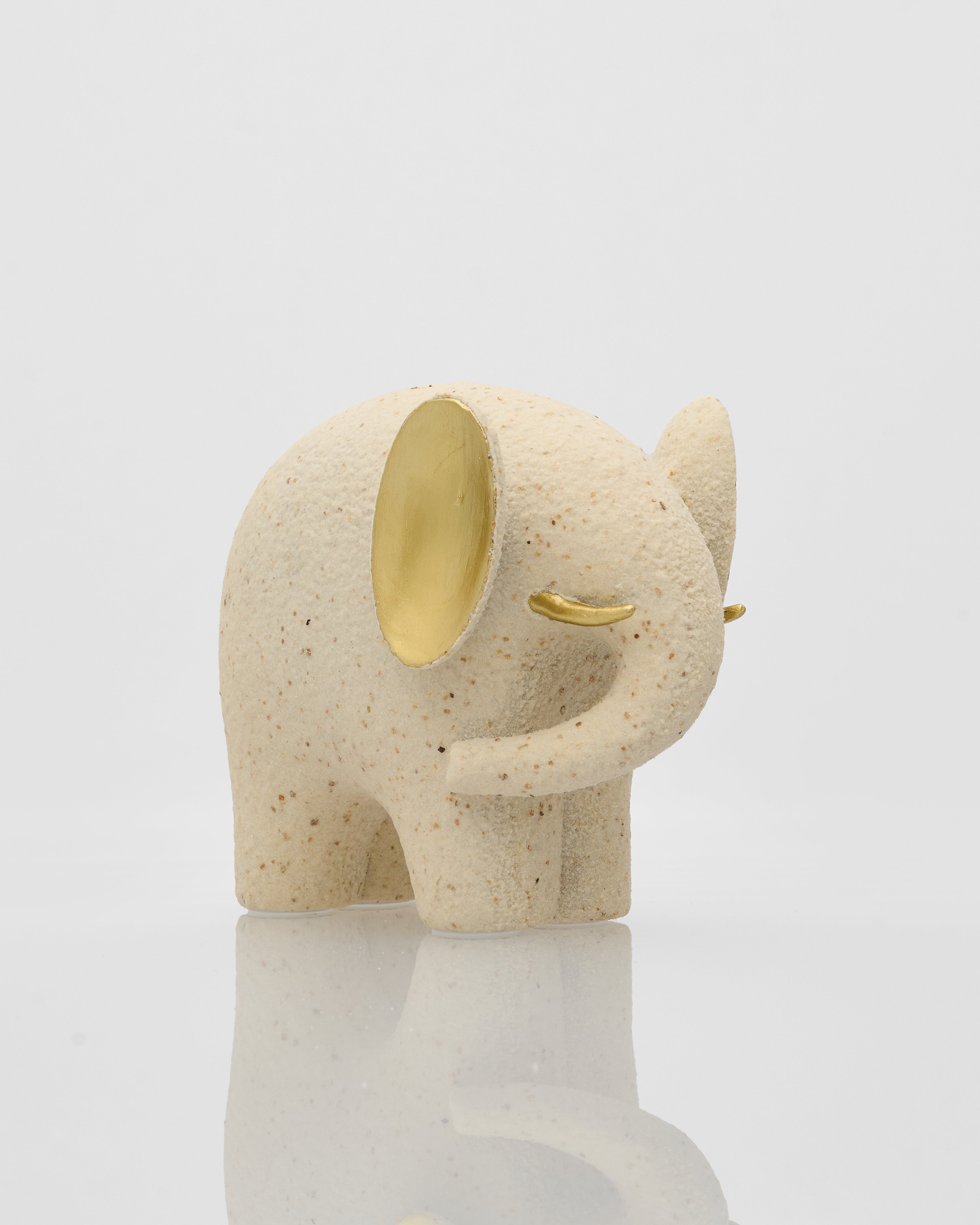 Decorative elephant figurine with gold accents on a light gray background
