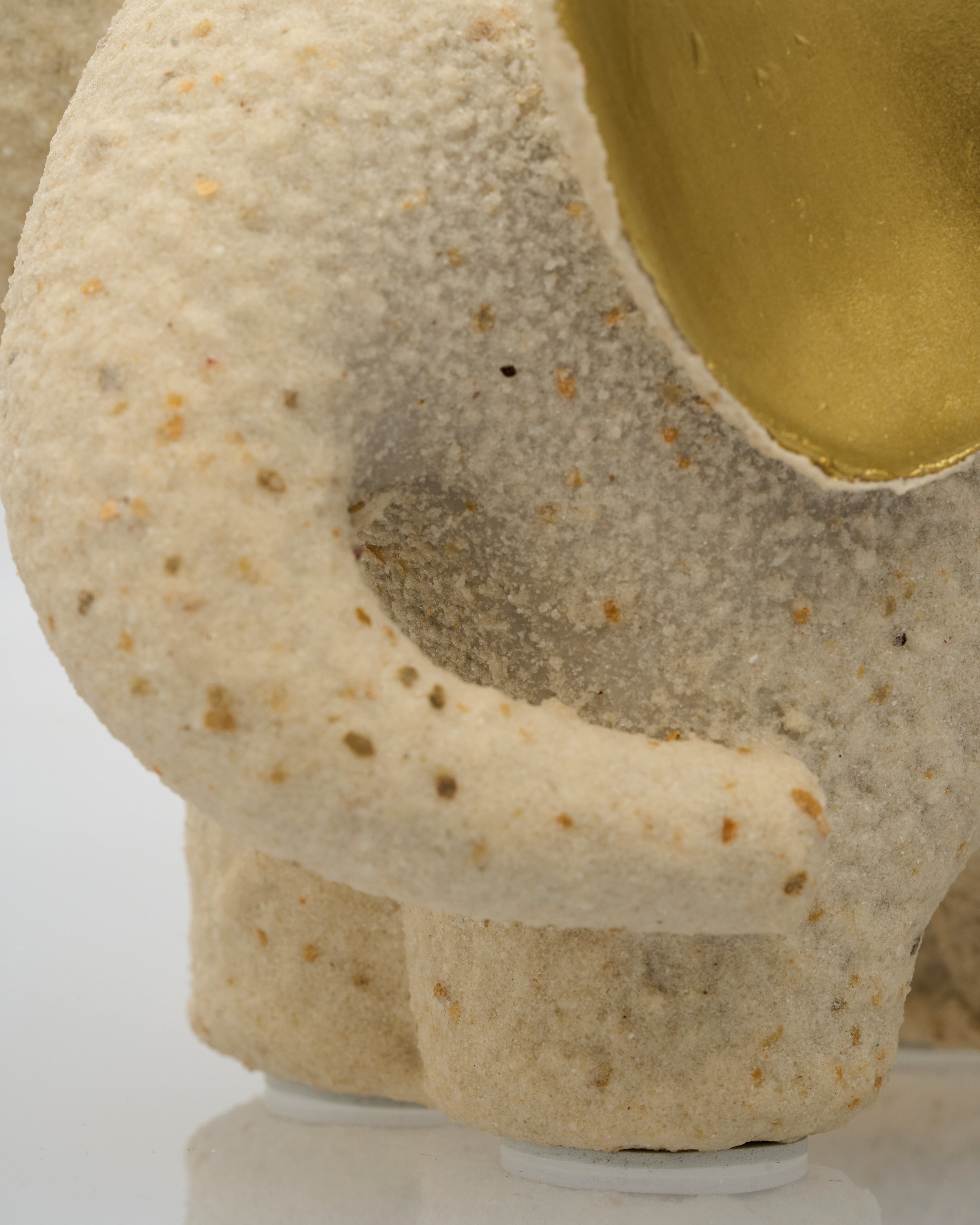 Close-up of a textured ceramic bowl with a gold interior on a white background
