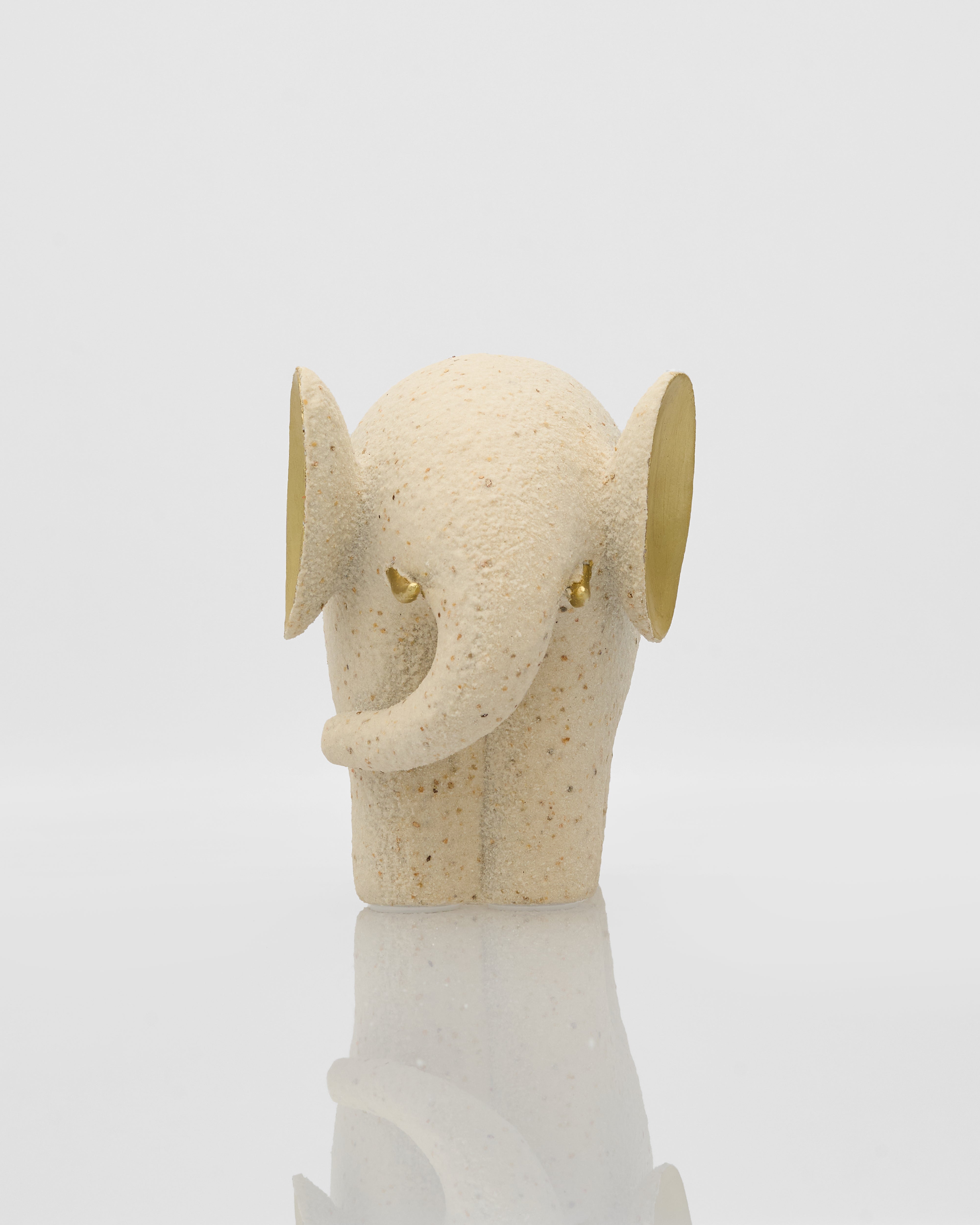 Decorative elephant head with gold accents on a white background