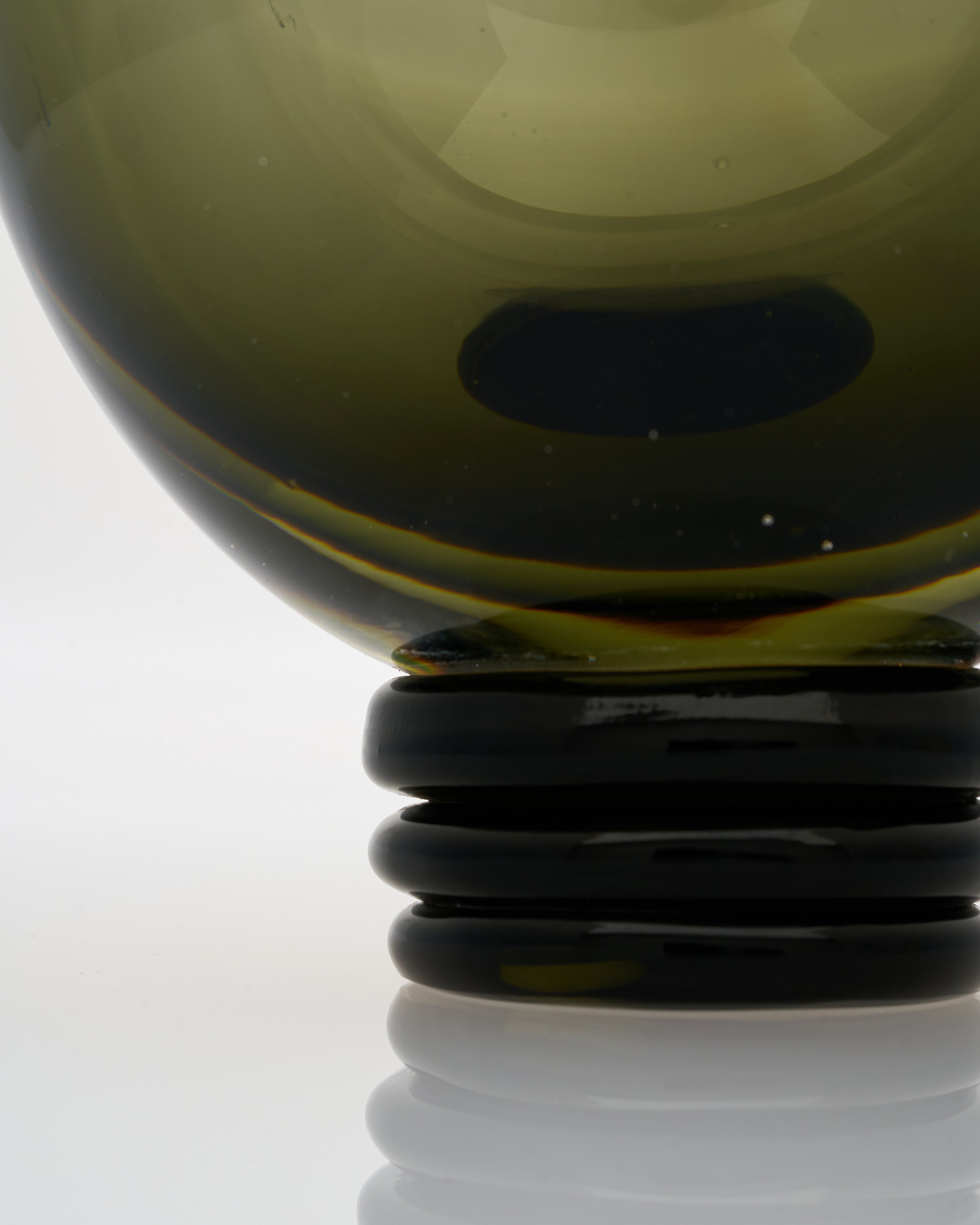 Close-up of contemporary green round vase detailing smooth surface and refined craftsmanship