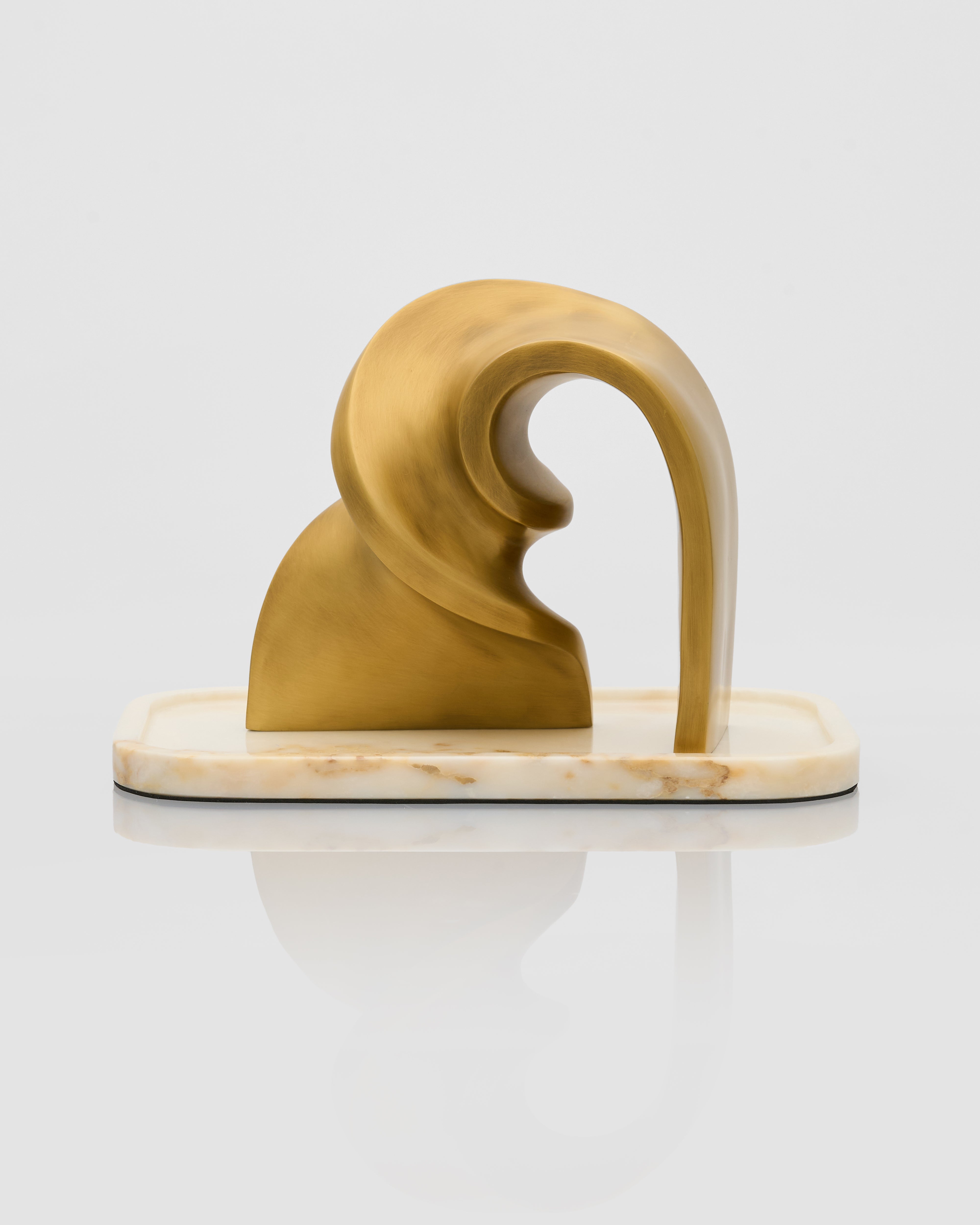 Decorative object with a gold and white design on a marble base against a white background