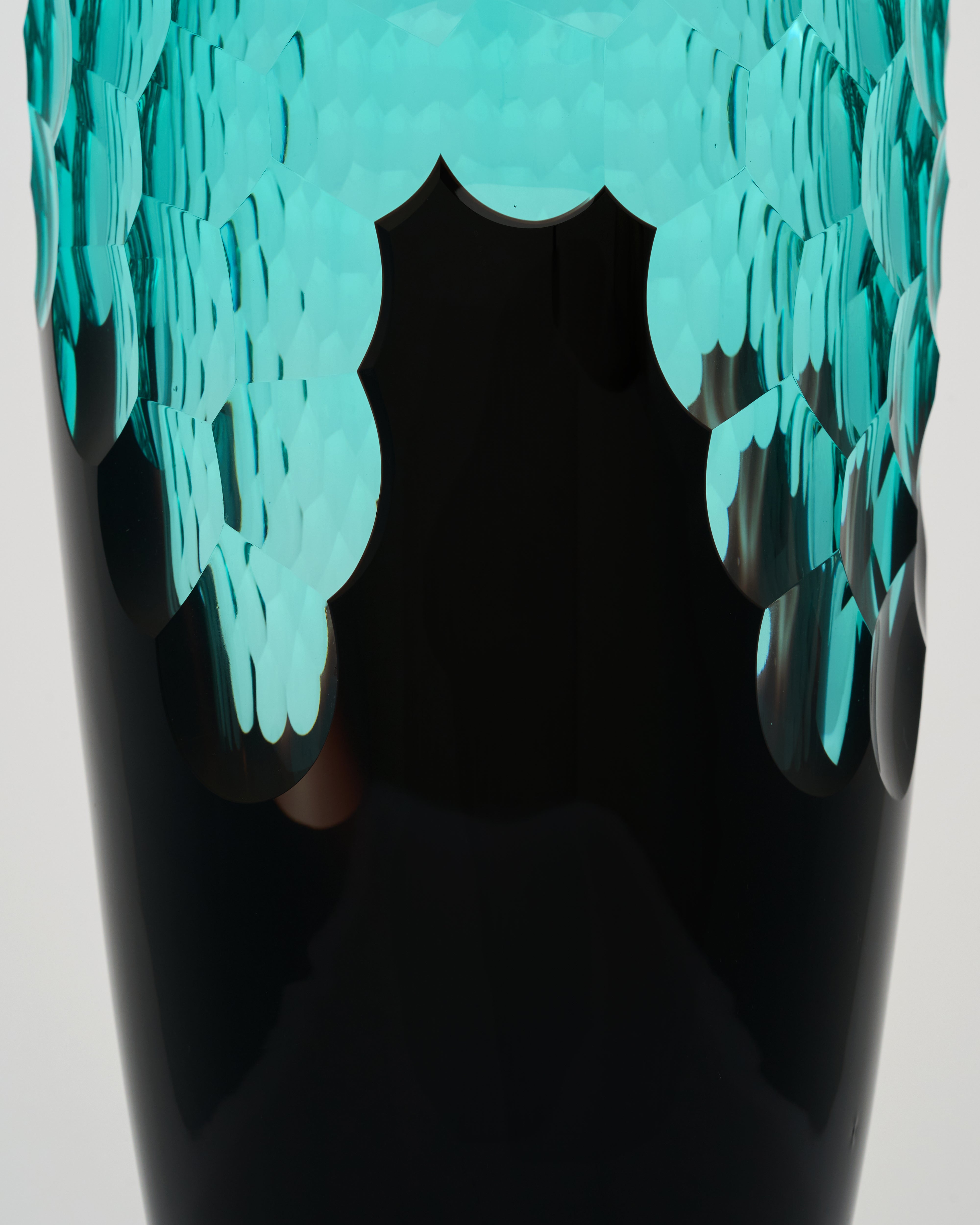 Black vase with turquoise decorative elements on a light gray background