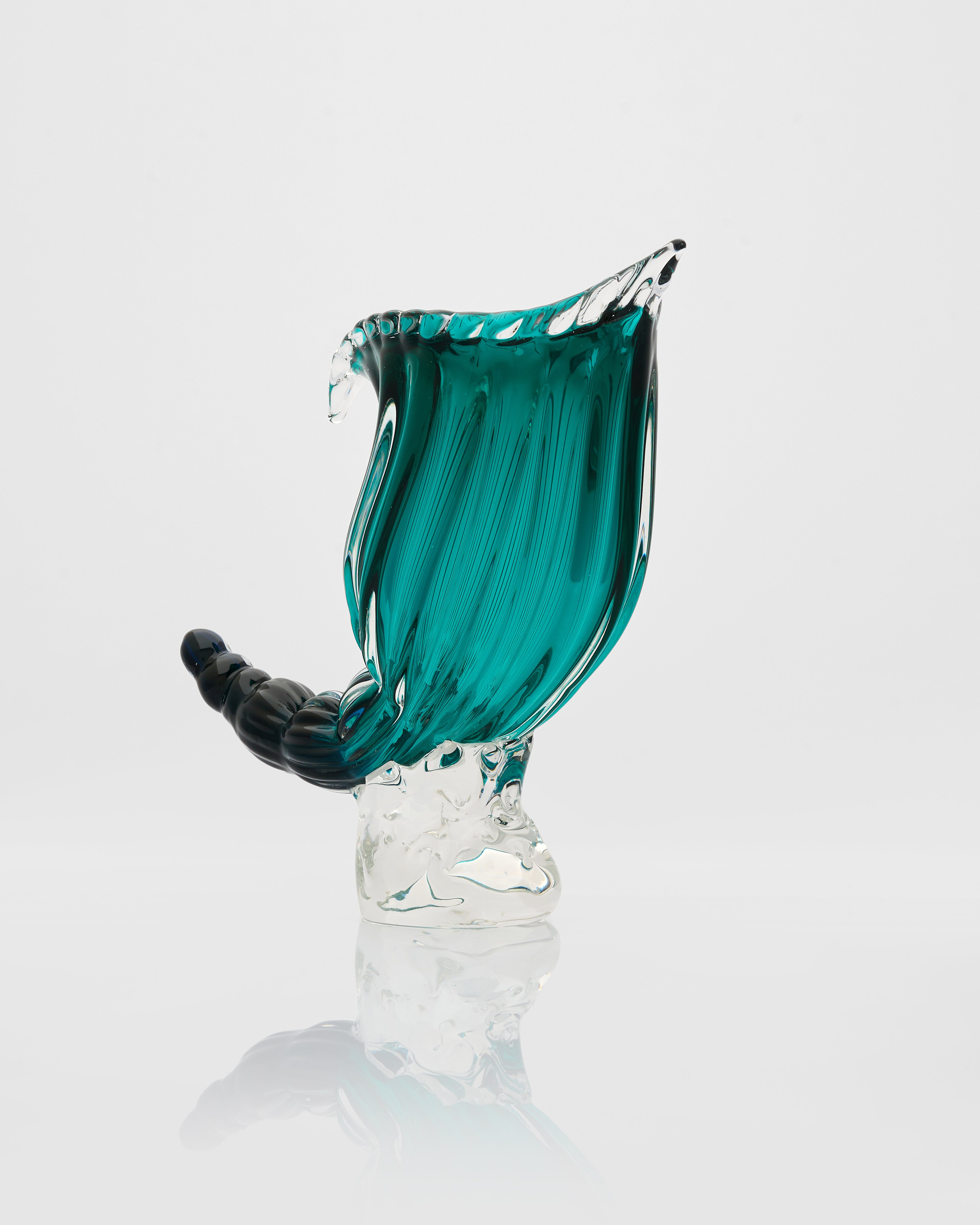 Glass sculpture with teal and clear design on a white background