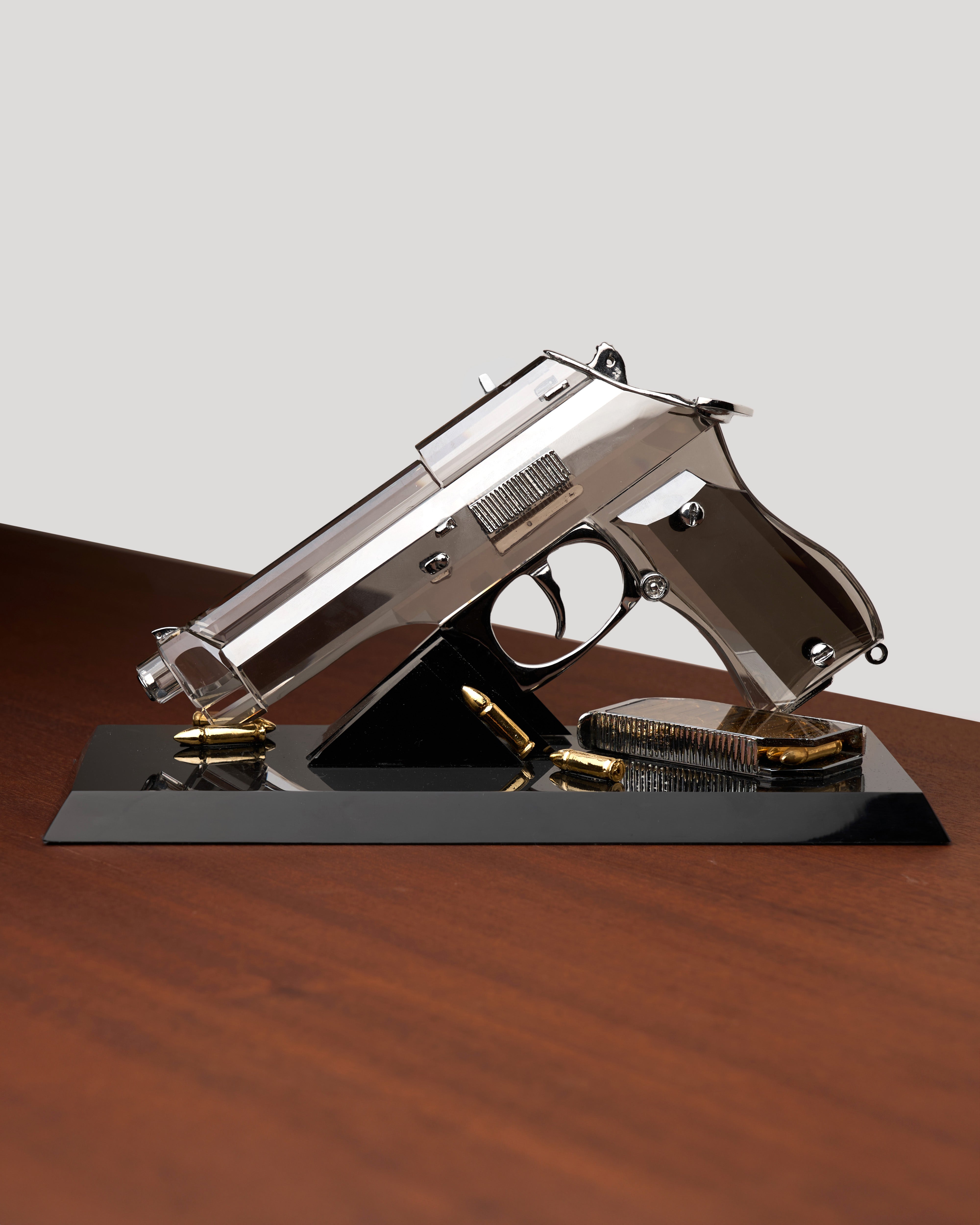 Chrome transparent gun-shaped crystal on black stand