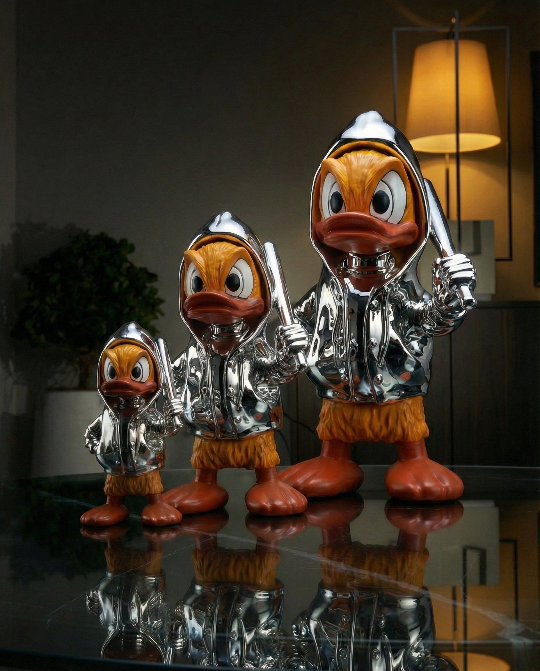 Three modern icon duck figurines wearing silver hoodies