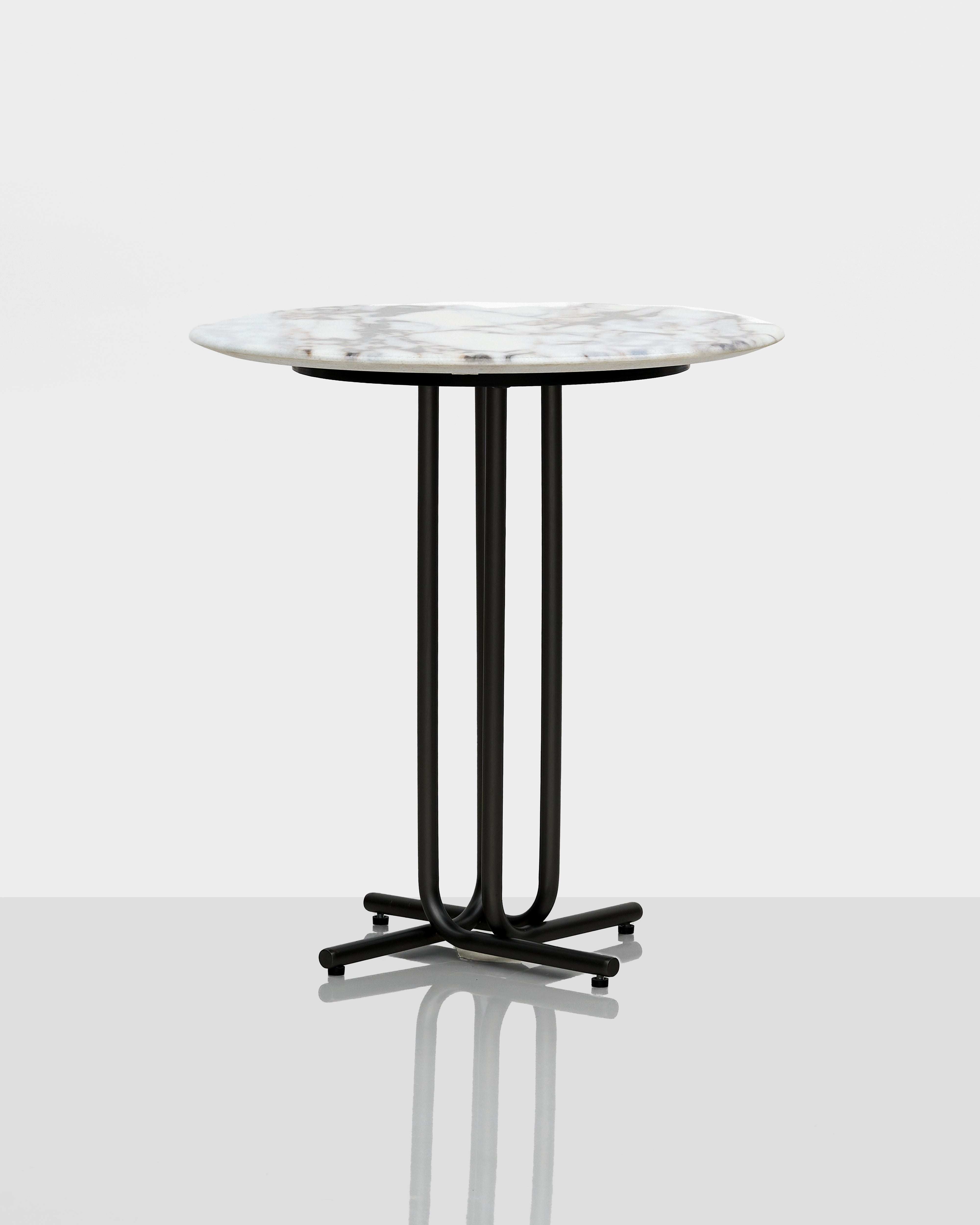 Round table with marble top and black metal base on a white background