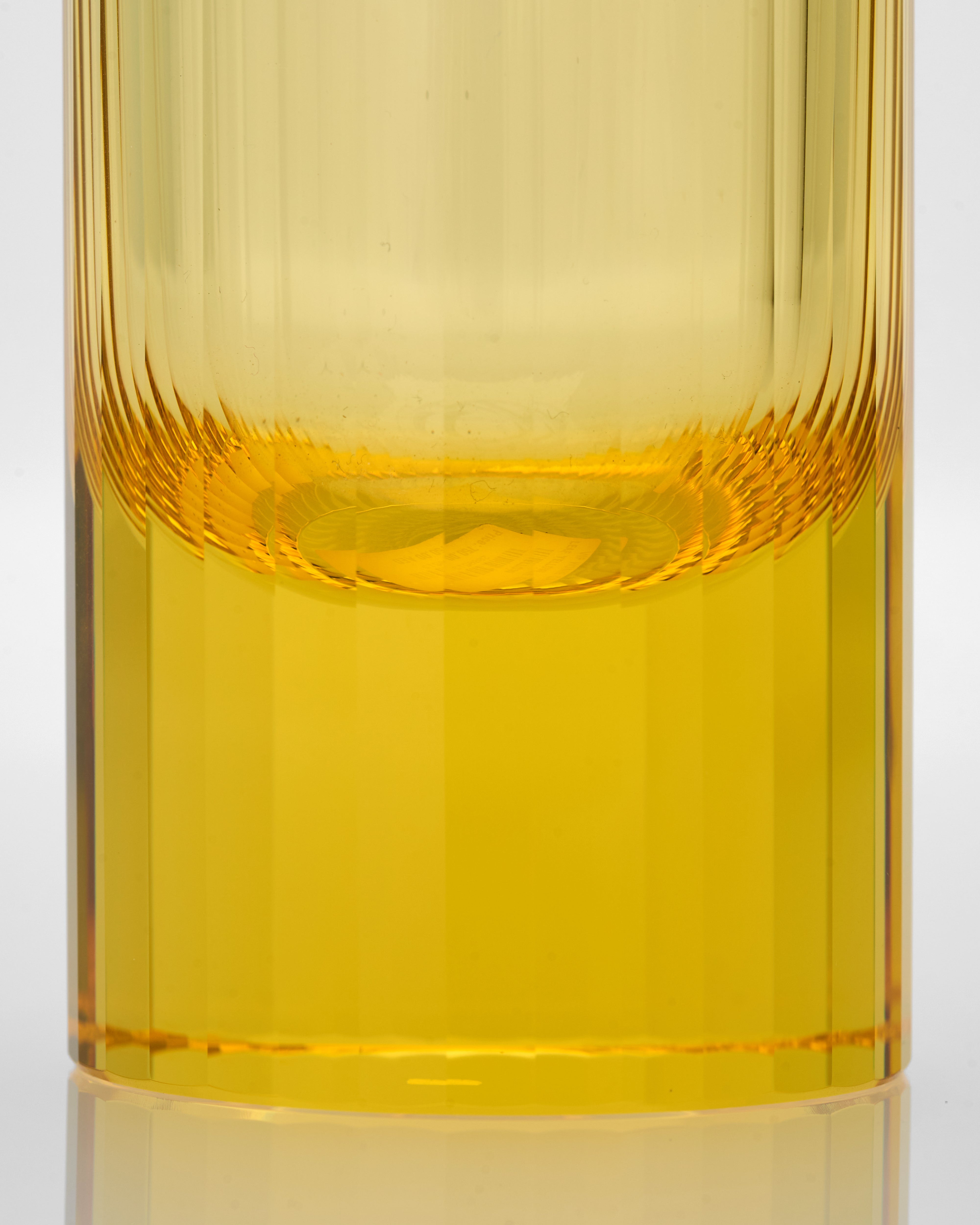 Yellow glass with textured surface on a white background