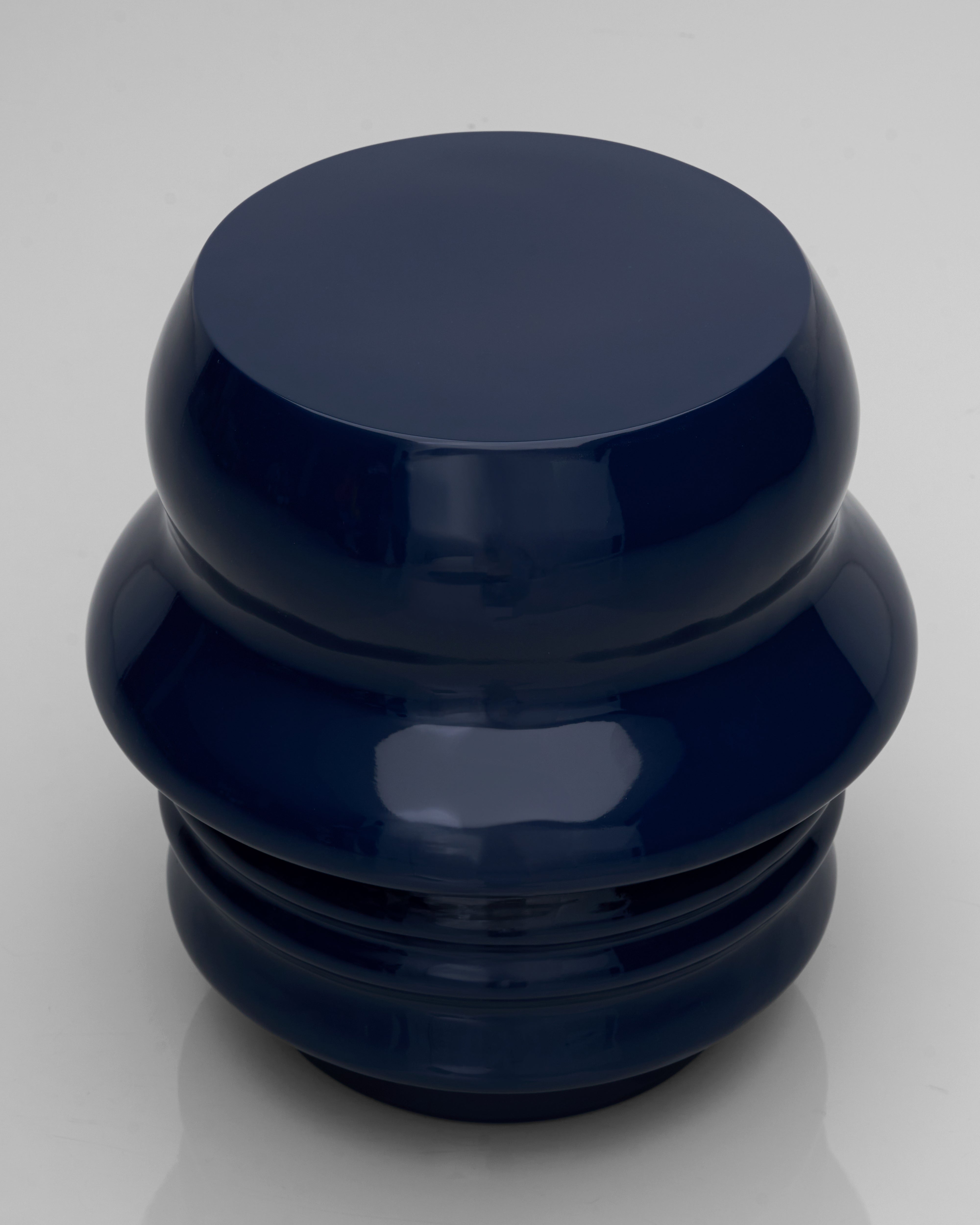 Front view of Felix duo face stool in navy blue showcasing sculptural facial detailing and refined craftsmanship