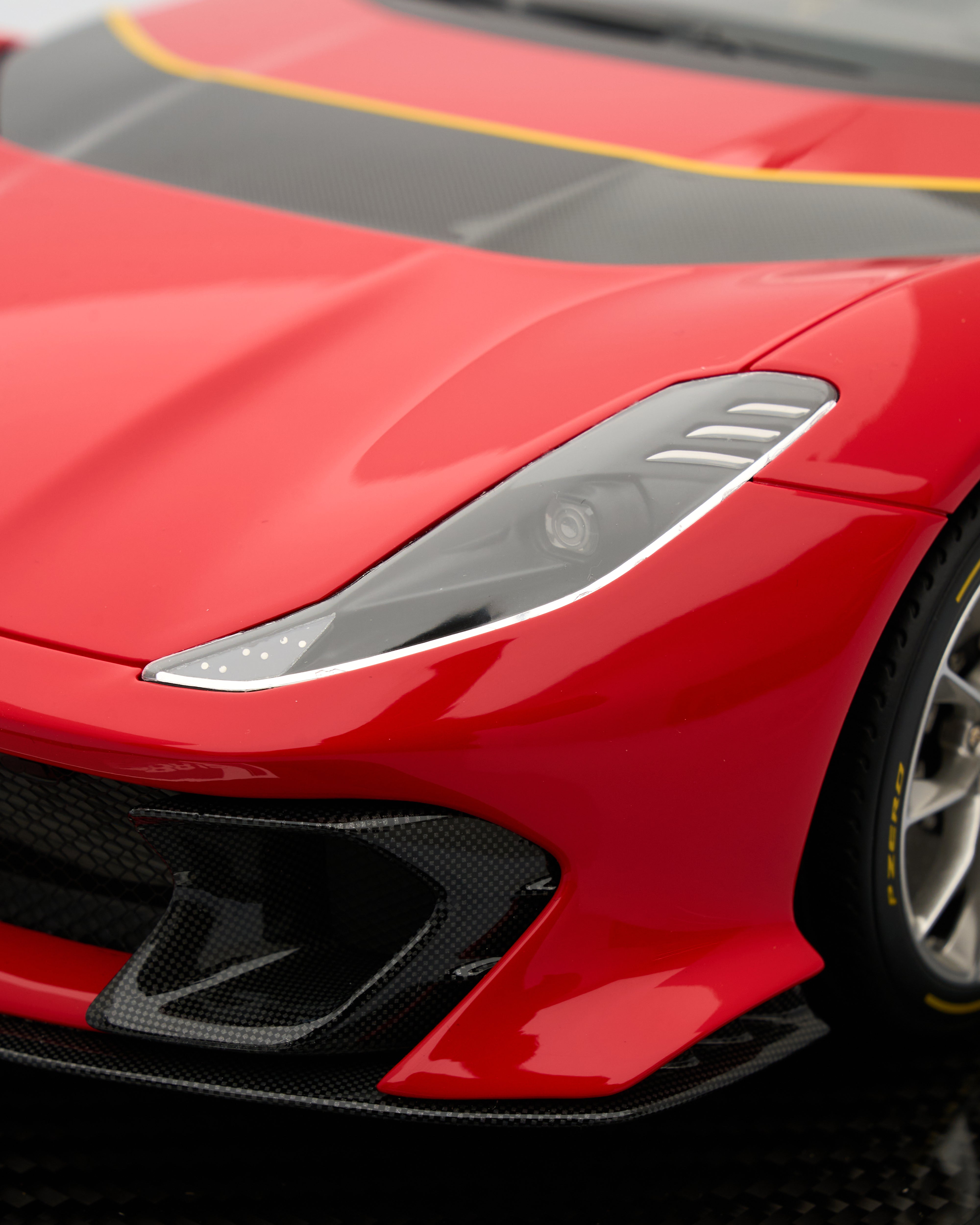 Close-up of a red sports car with a black and yellow stripe