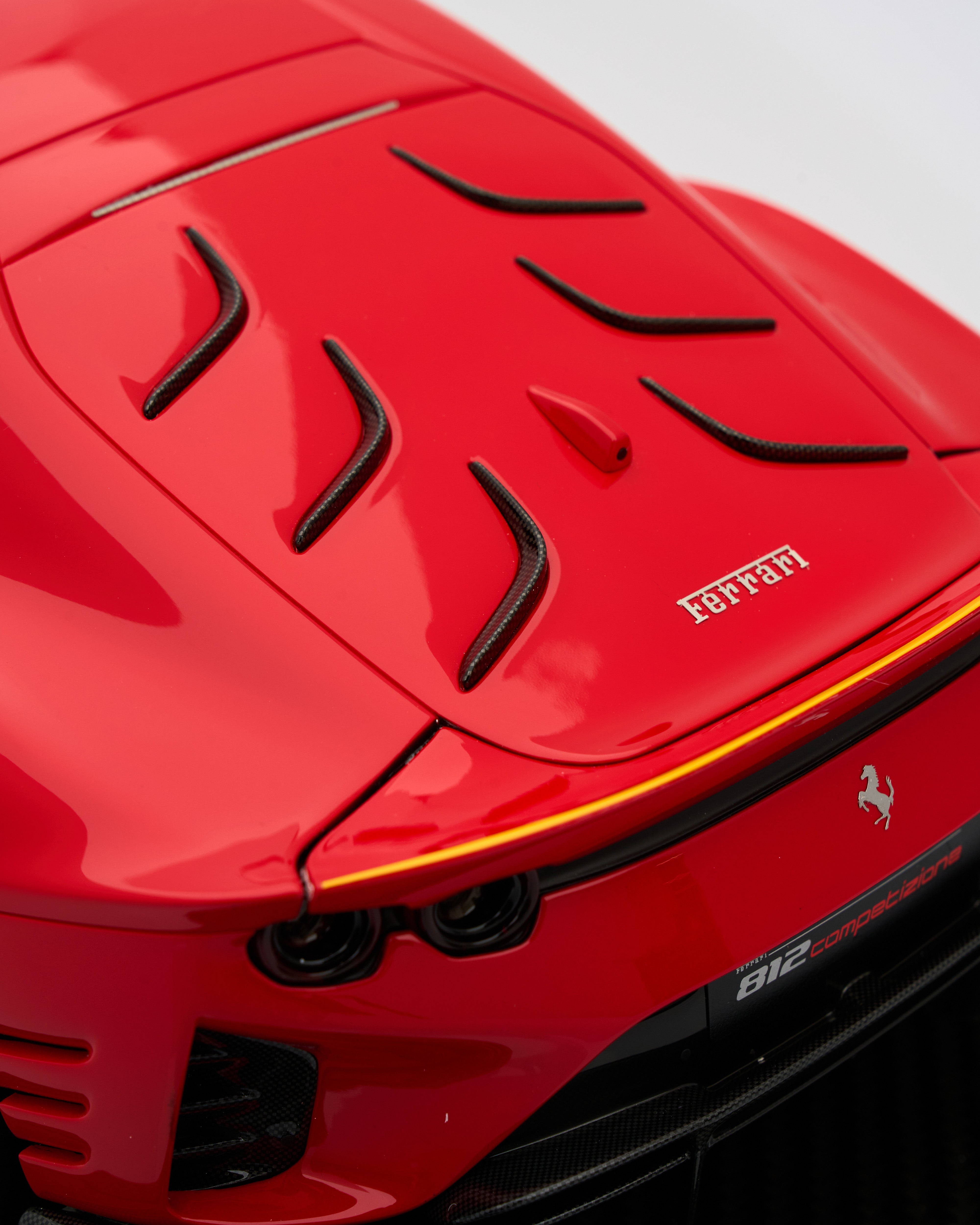 Close-up of a red Ferrari car with the logo and model number visible.