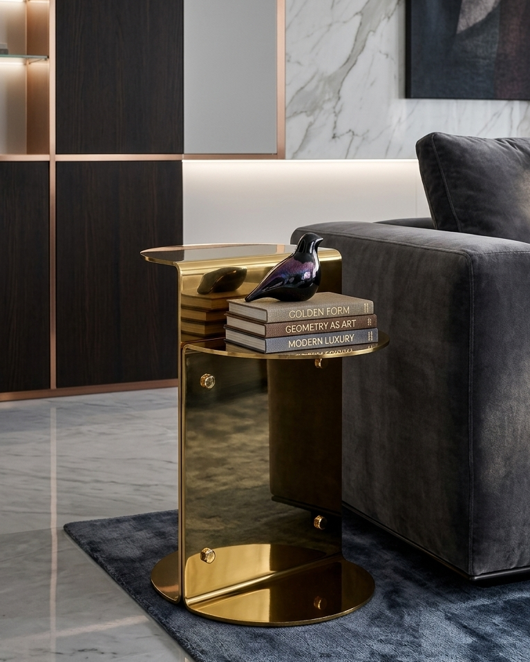 Gold side table with books and a bird figurine in a modern living room setting.
