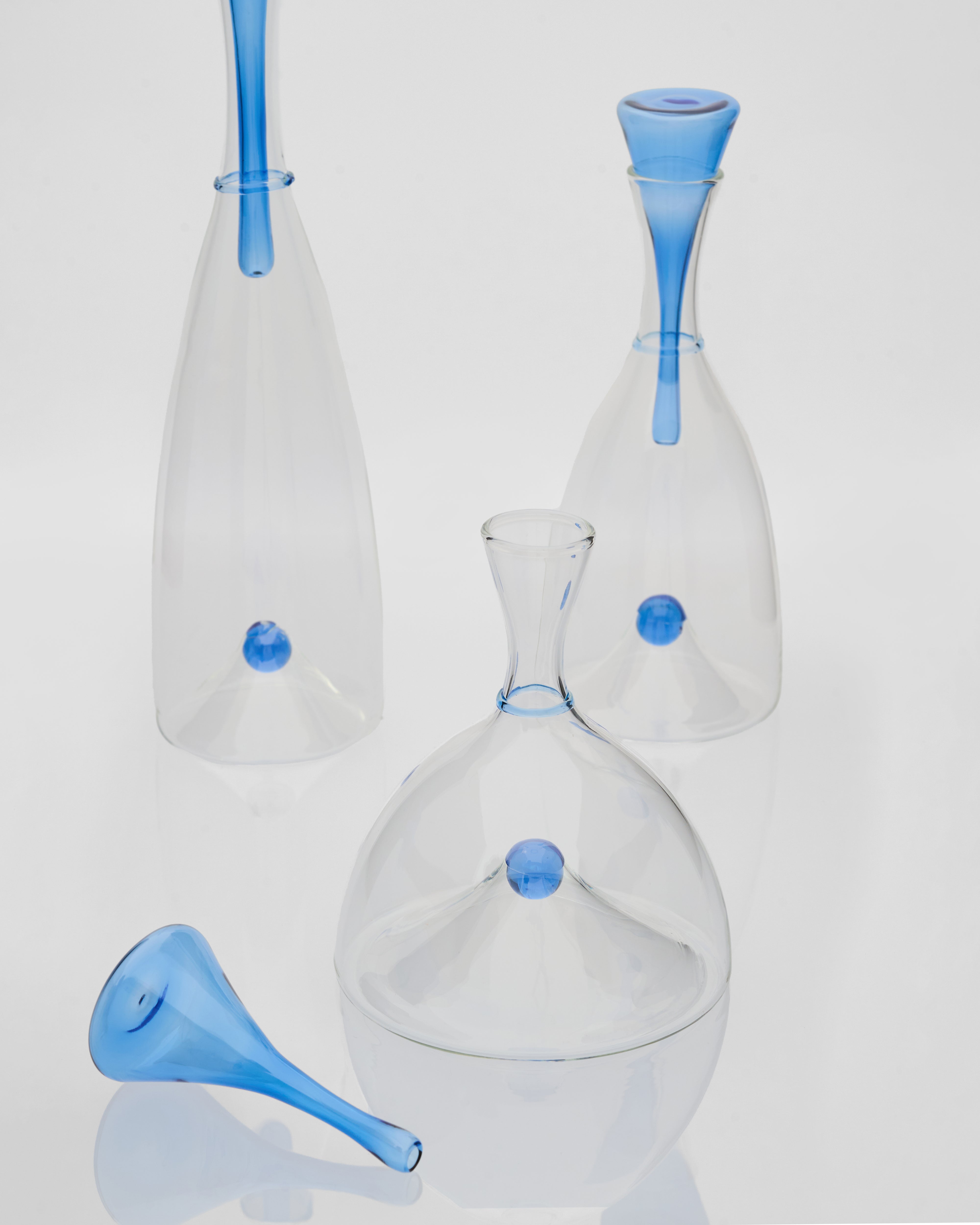 Clear glass bottles with blue accents on a light gray background