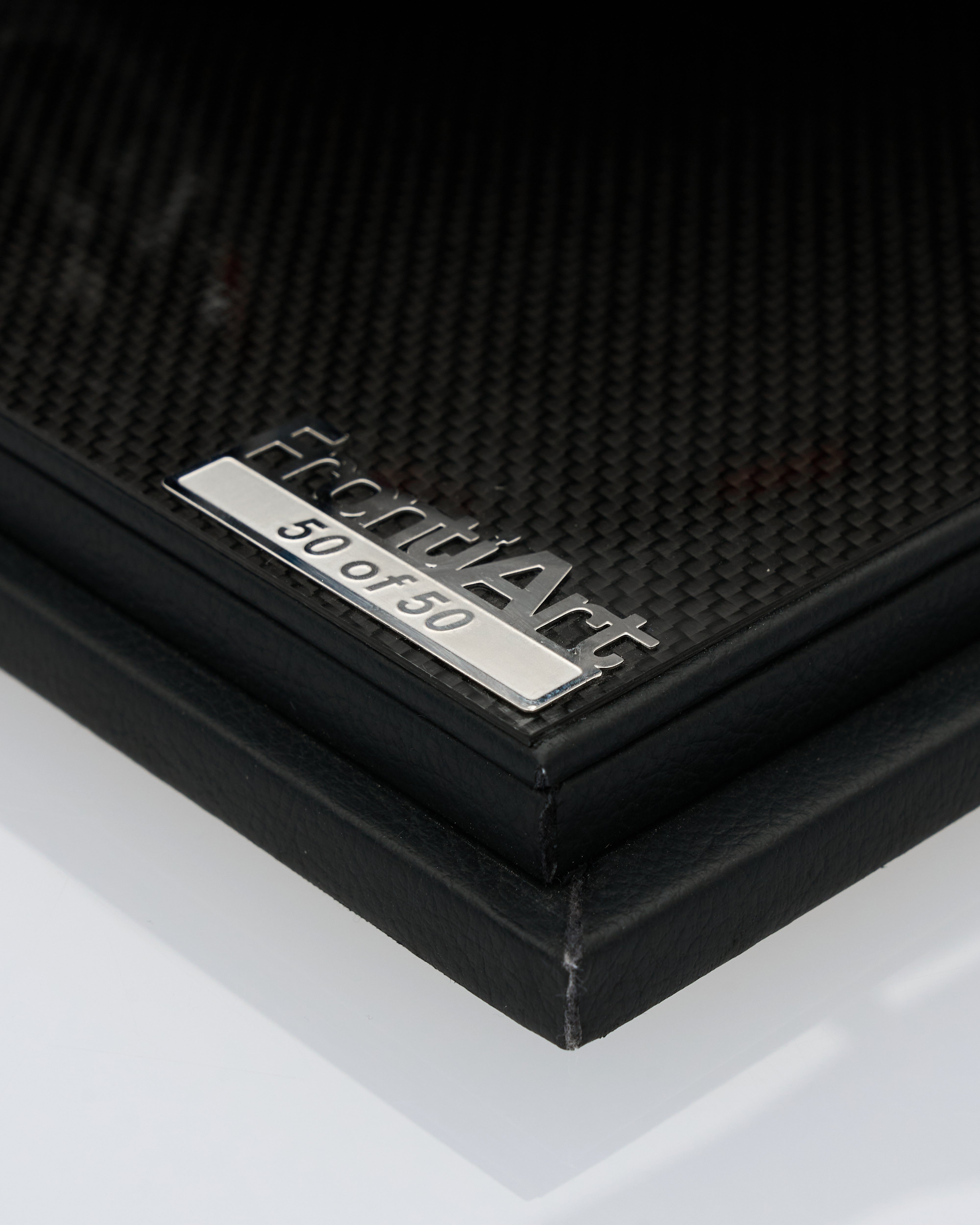 Close-up of a black leather product with a silver label on a white background