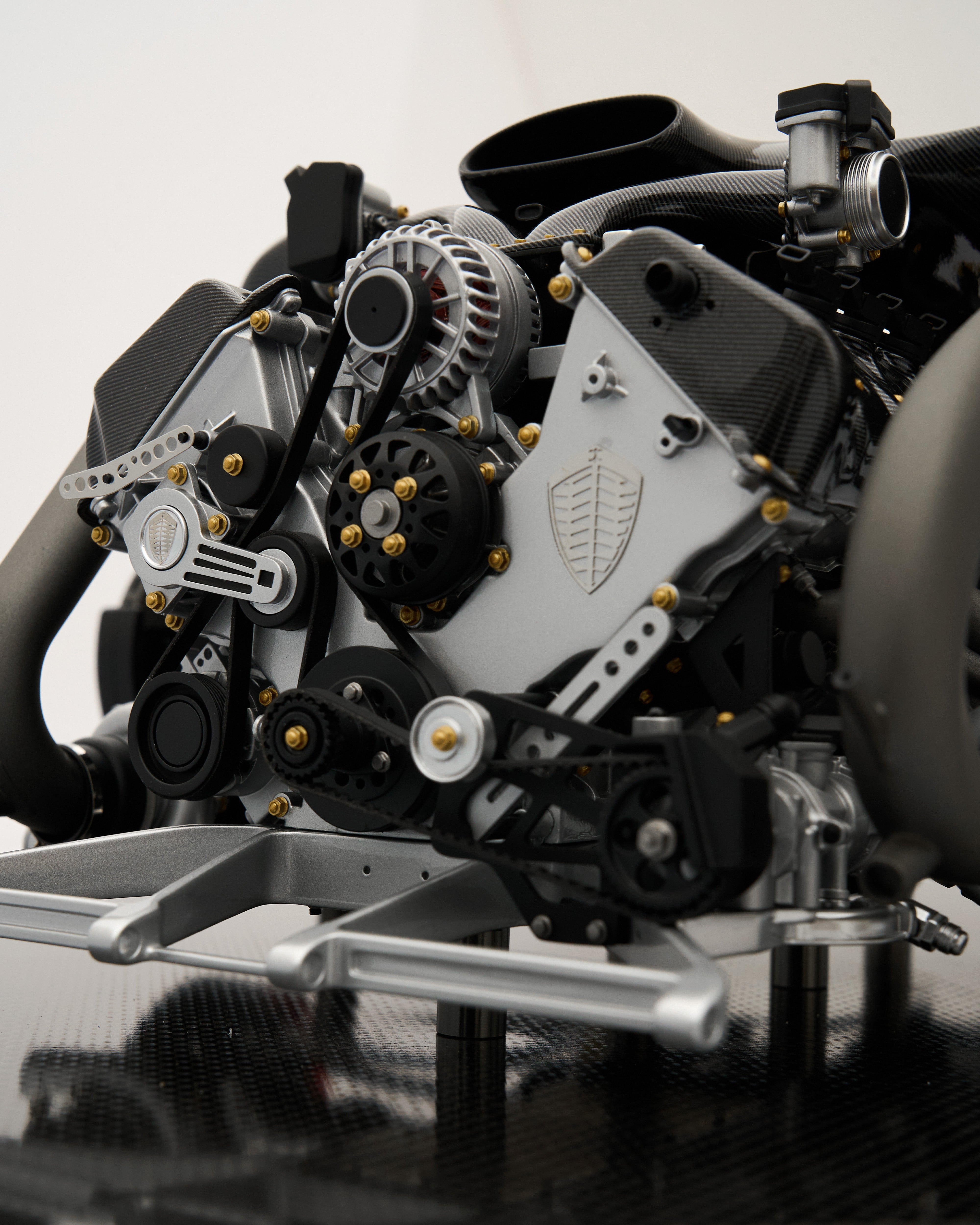 Close-up of a car engine with visible brand logo on a reflective surface.