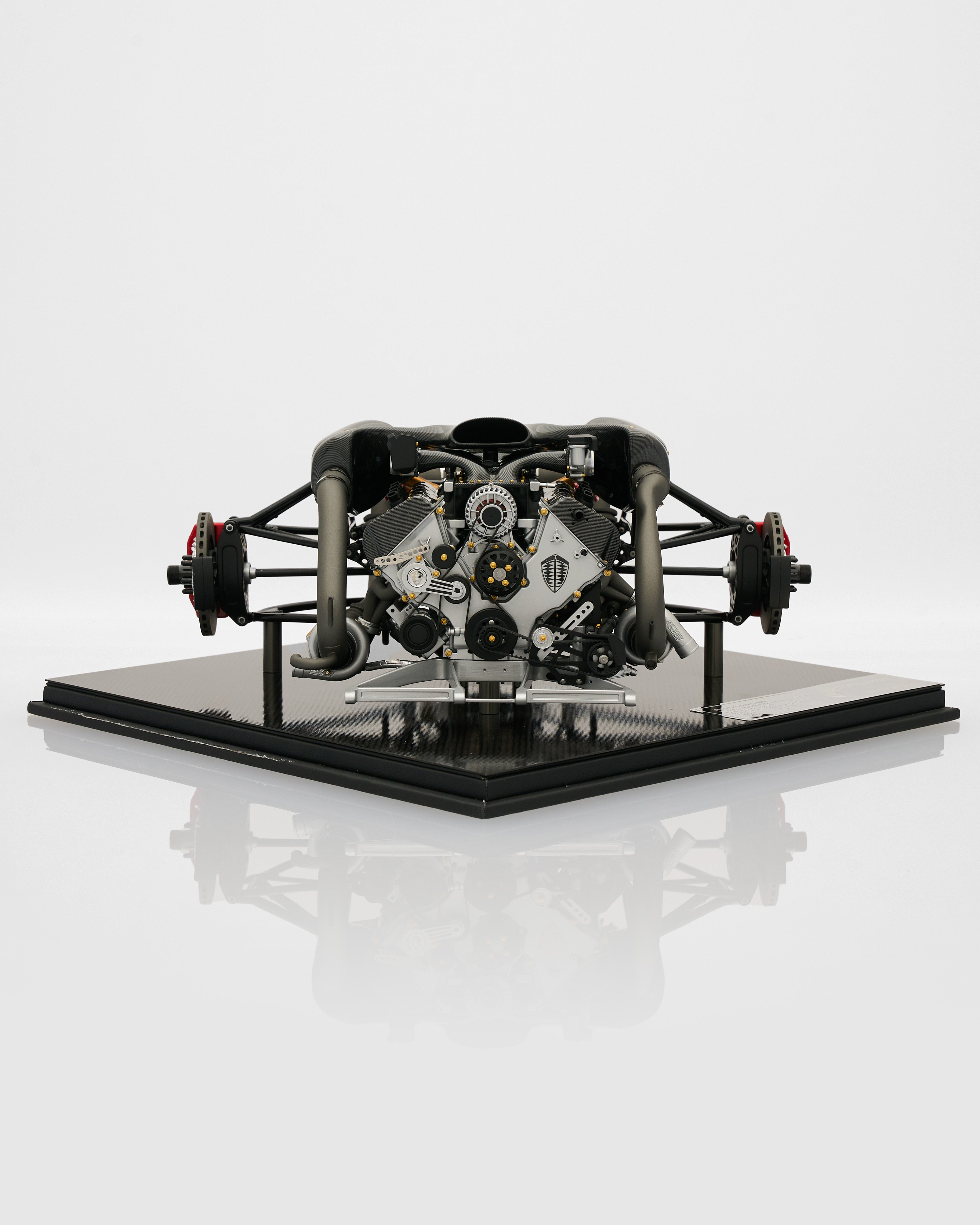Model of a mechanical engine on a reflective surface with a white background