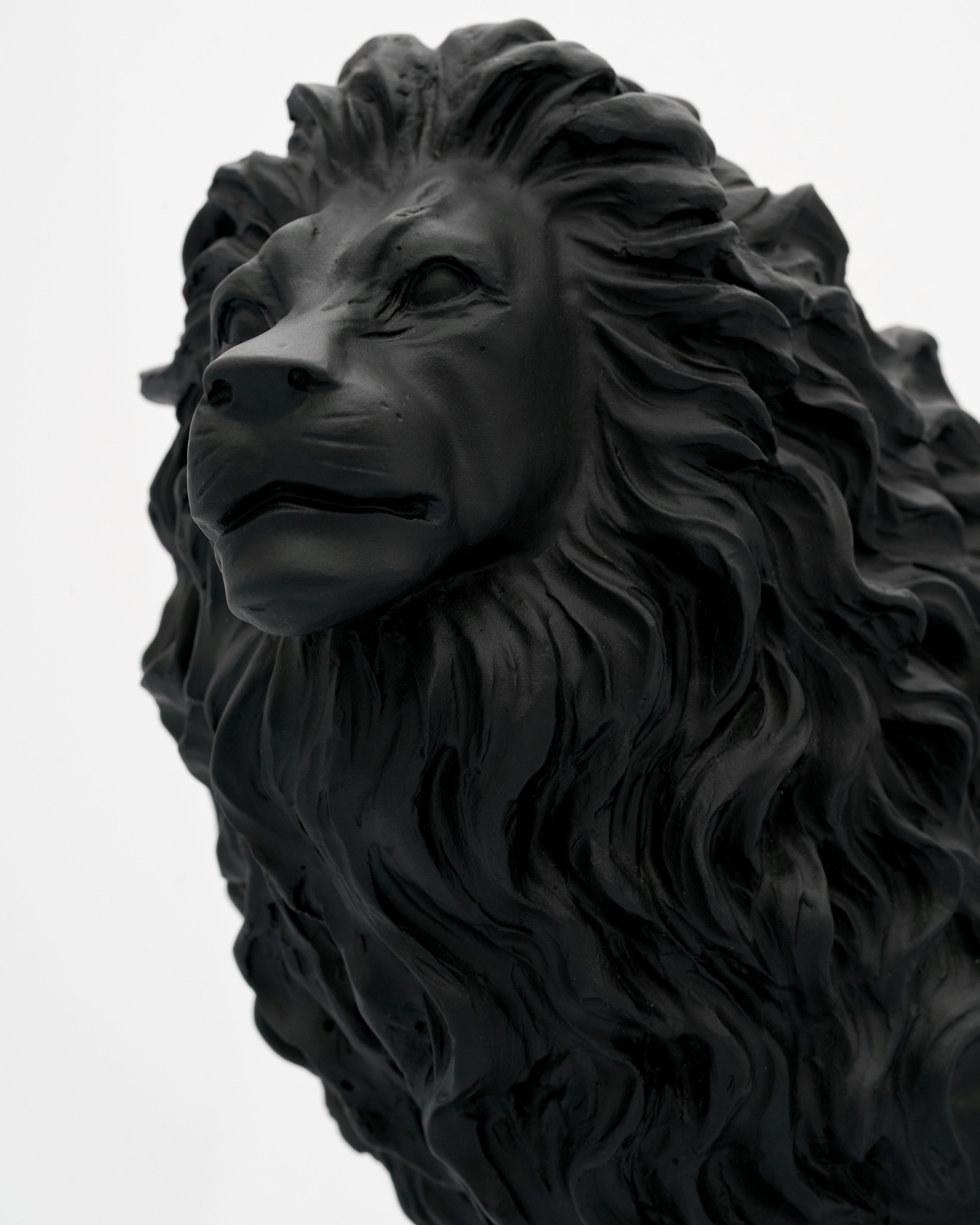 Black lion statue on a white background close lion face