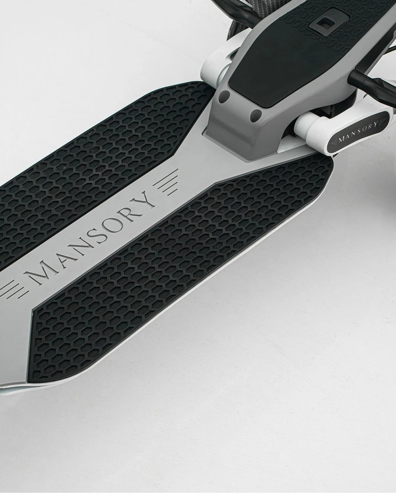 Close-up of a scooter white with 'Mansory' branding on a white background